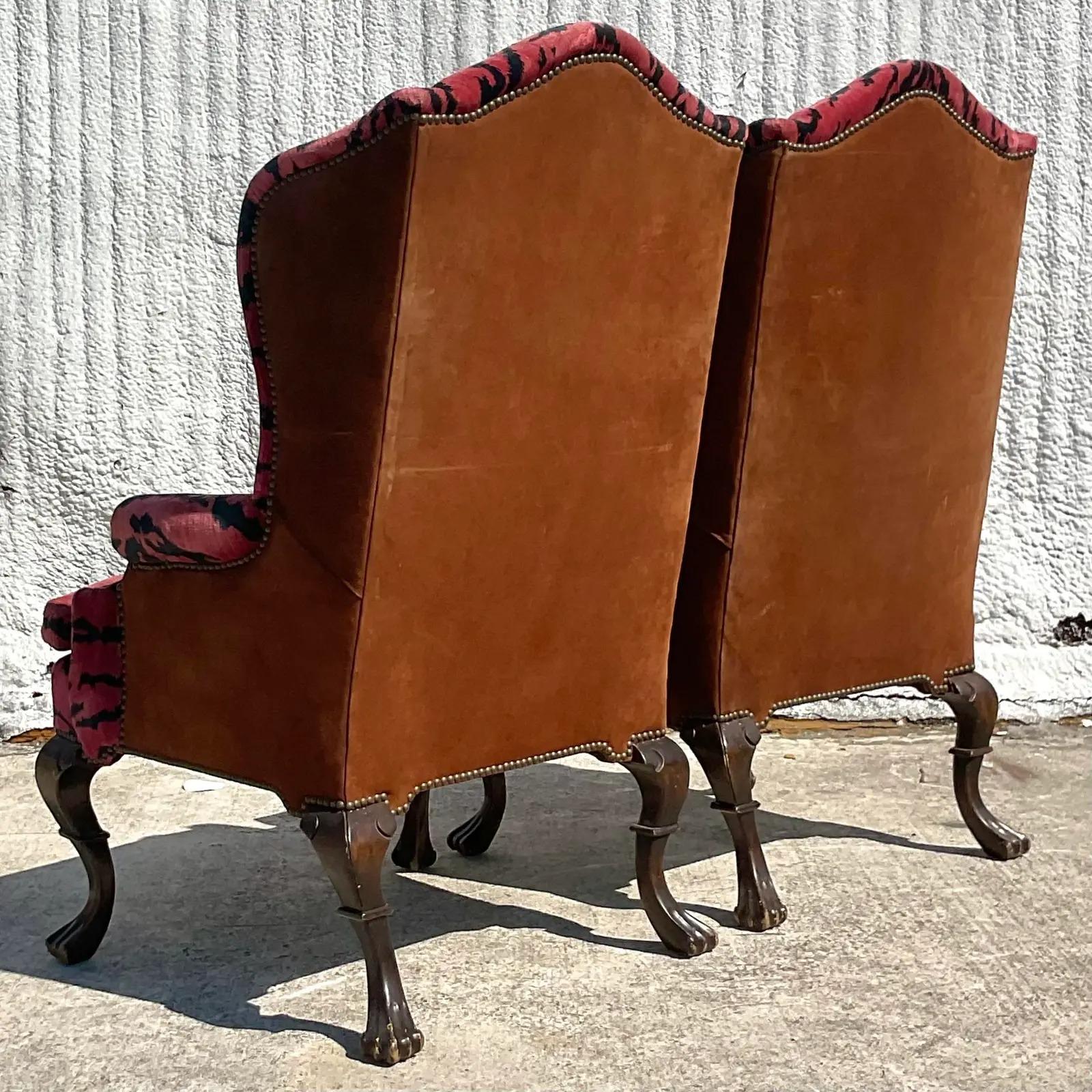 A fantastic pair of vintage Regency wingback chairs. Covered in the legendary Scalamandre. “Le Tiger” velvet. Wrapped in a caramel suede. Beautiful carved cabriolet legs.