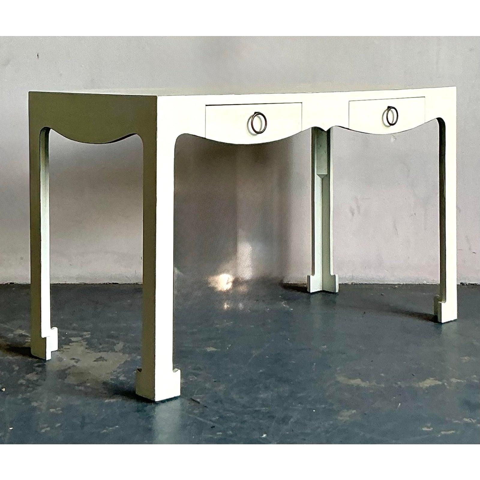 Presenting a chic vintage writing desk, exuding the glamorous allure of the Hollywood Regency era. This elegant piece features a beautifully scalloped apron and a sleek ivory lacquered finish, offering a sophisticated aesthetic that brightens any