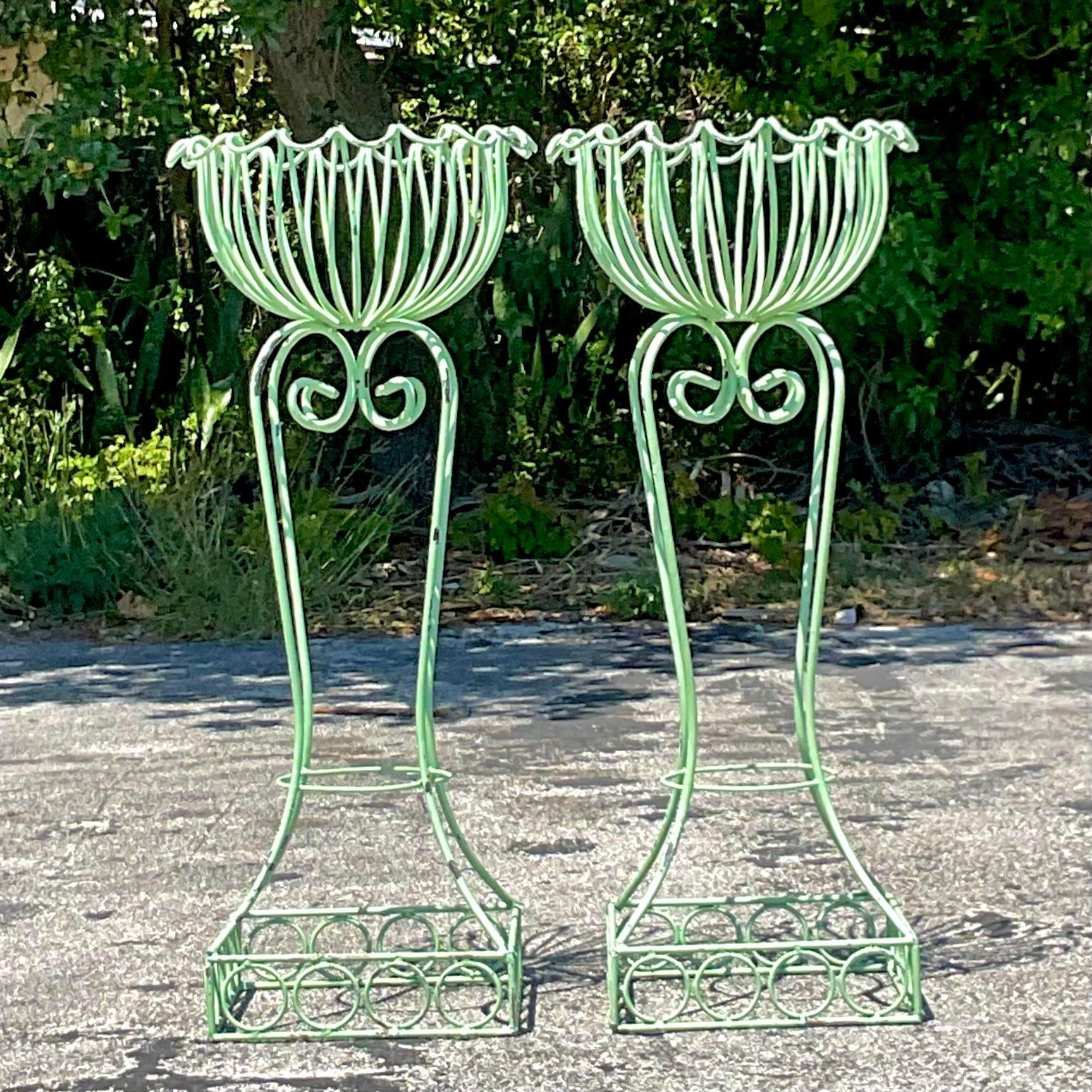 Enhance your botanical display with this pair of vintage Regency wrought iron plant stands. Featuring scalloped edges and elegant design, these American-crafted stands elevate your plants while adding a touch of timeless sophistication to your