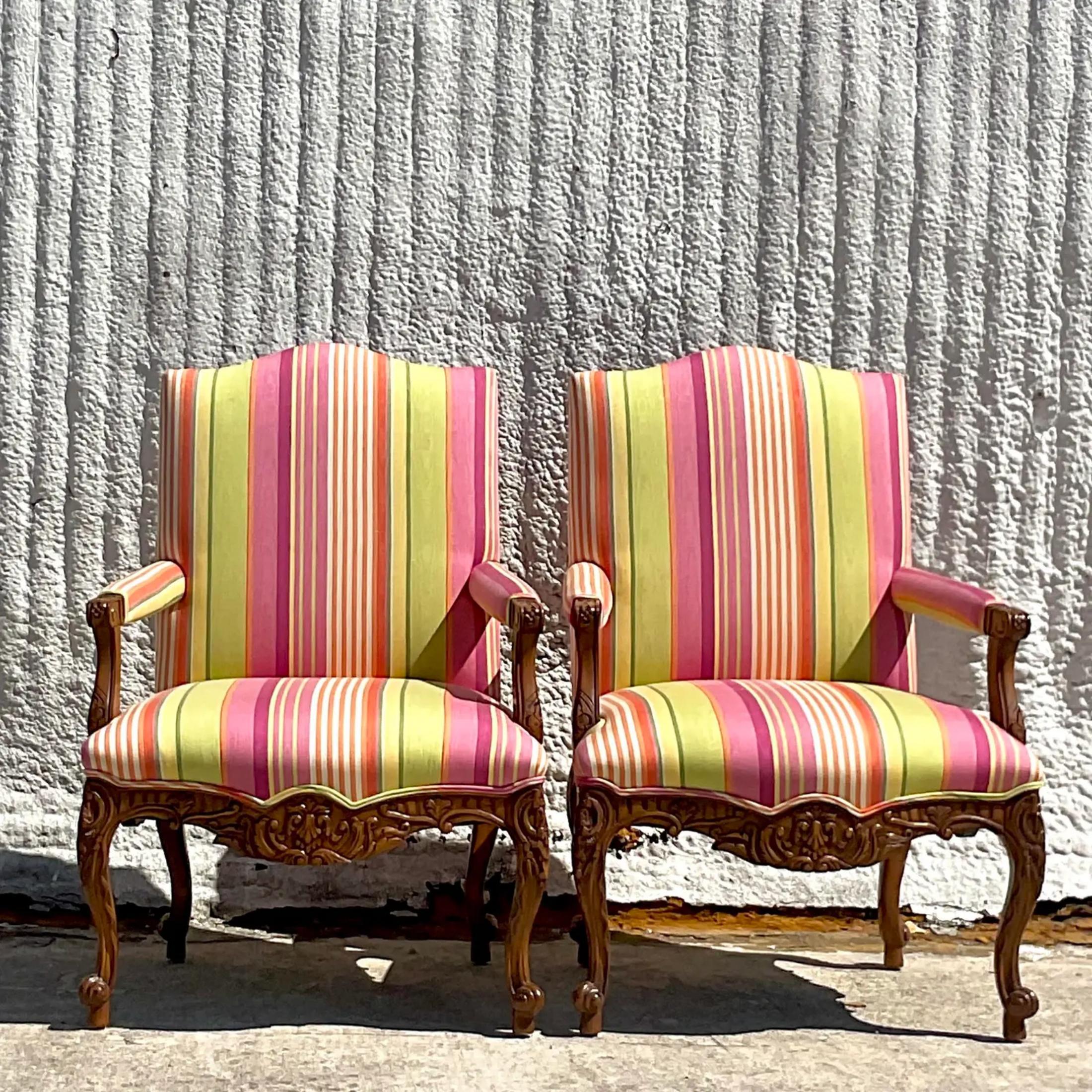 An exceptional pair of vintage Regency Louis XV style chairs. A gorgeous Schumacher strip in brilliant clear colors. Stunning hand carved detail. Acquired from a Palm Bech estate