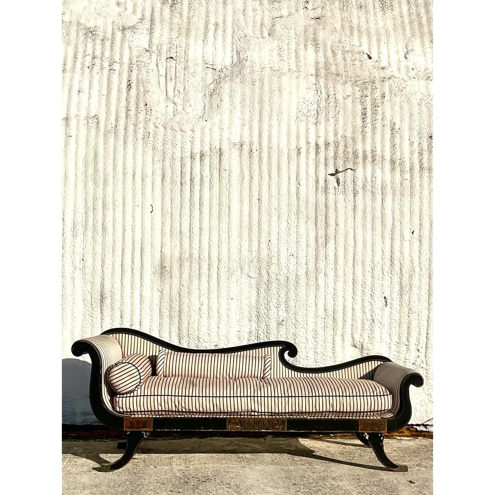 Vintage Regency scroll arm settee. Beautiful paint over gesso frame with beautiful gilt detail. Chic striped silk matlese upholstery with two bolster pillows. Acquired from a Palm Beach estate.

The settee is in good vintage condition. Scrapes,