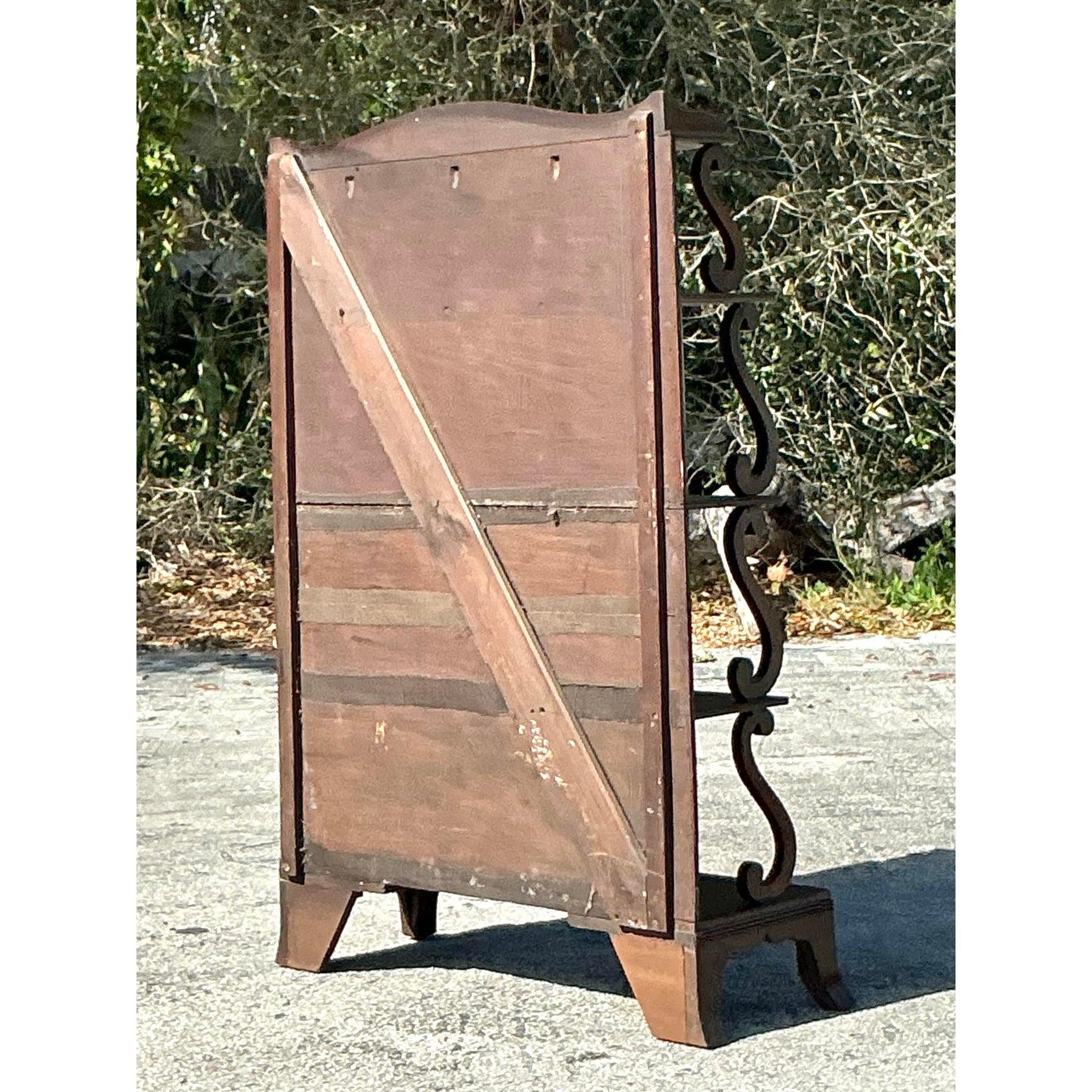 Aggiungi un tocco di eleganza senza tempo alla tua casa con questa squisita étagère aperta in stile Regency vintage. Caratterizzata da supporti laterali graziosamente arcuati, questa splendida libreria è realizzata in legno riccamente rifinito, che