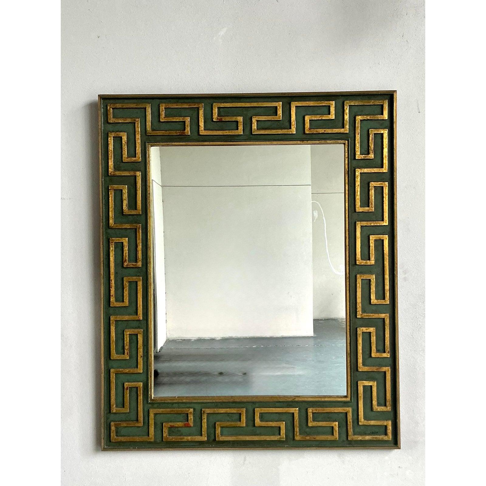 Dieser außergewöhnliche Wandspiegel im Hollywood-Regency-Stil, signiert von der renommierten Künstlerin Nancy Jolly, wertet Ihre Einrichtung auf. Dieses fesselnde Stück zeigt ein kühnes, ikonisches Greek Key-Motiv, das kunstvoll geschnitzt und in