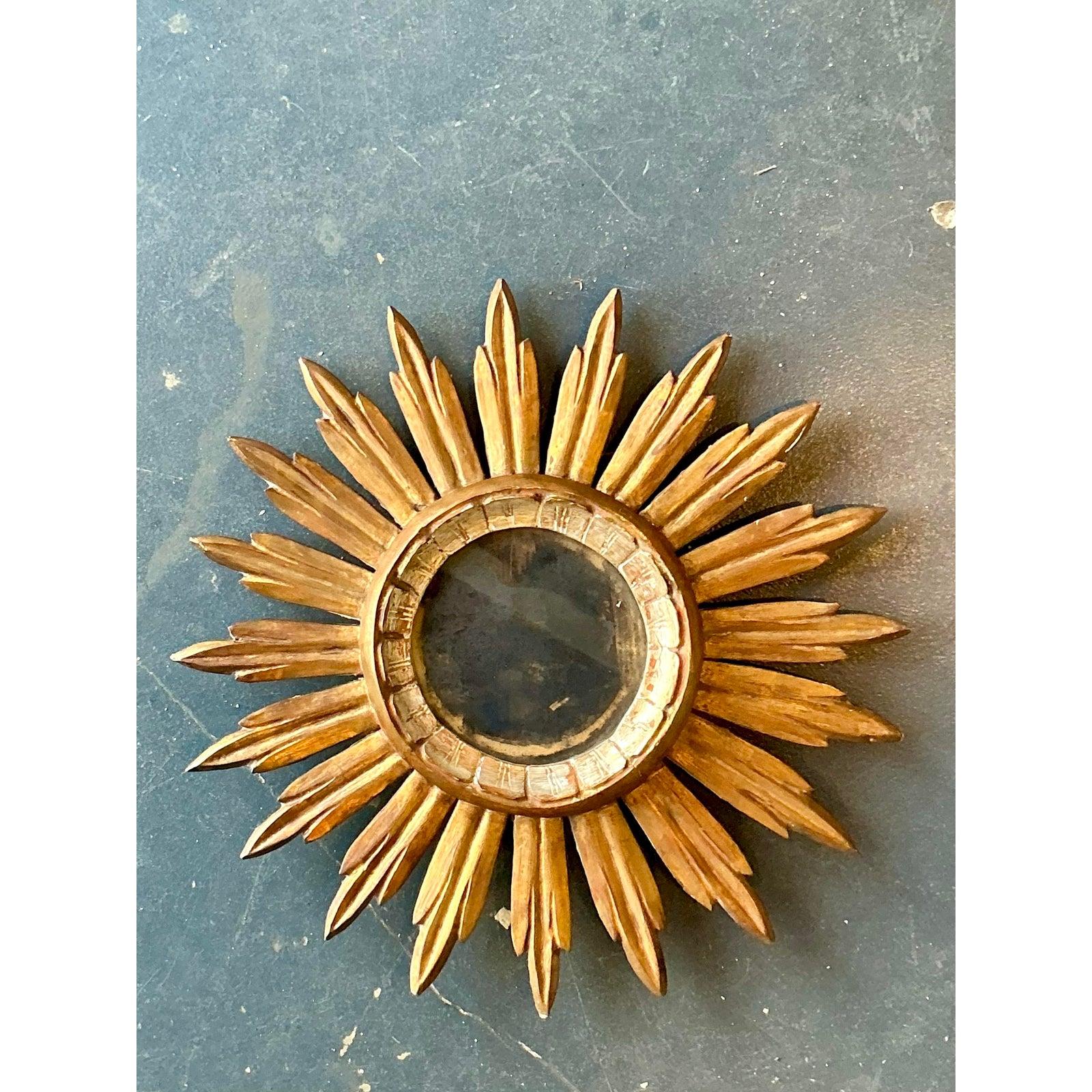 Fangen Sie die strahlende Eleganz des klassischen spanischen Designs mit diesem exquisiten vergoldeten Sonnenschliff-Spiegel im Vintage-Stil ein. Jeder einzelne Strahl ist meisterhaft von Hand aus Holz geschnitzt, geriffelt und geschichtet, um eine