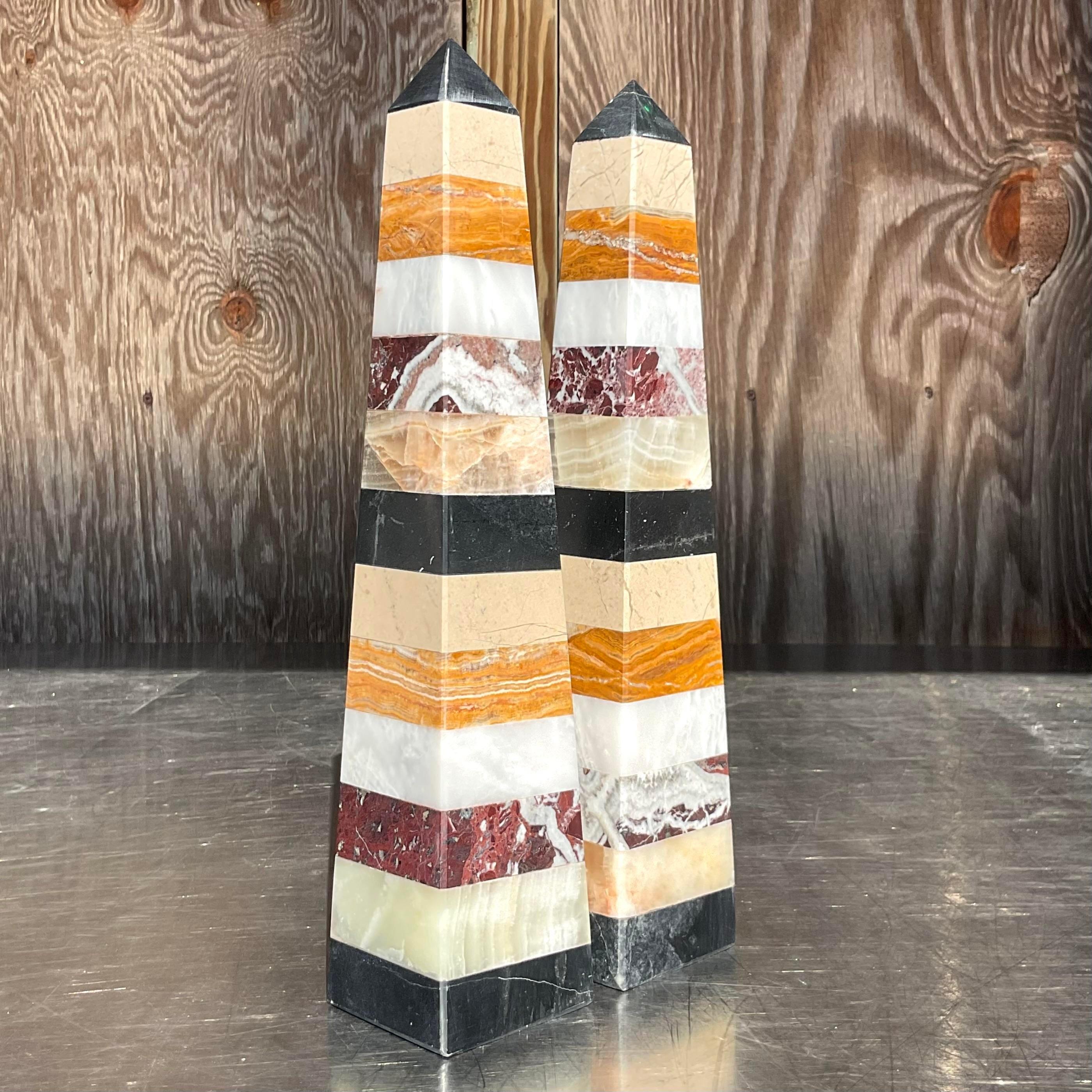 A stunning pair of vintage Boho obelisks. A chic multi colored stacked stone in a gorgeous polished finish. Acquired from a Palm Beach estate.