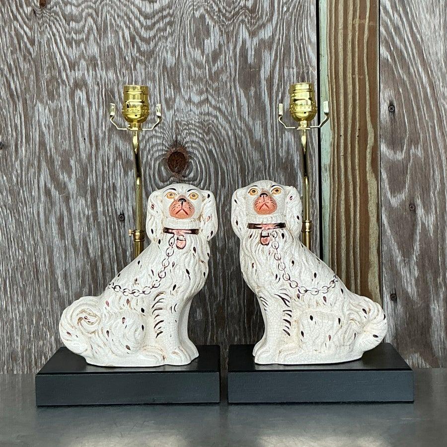 Elevate your interior with this stunning pair of vintage Staffordshire dog lamps. Featuring the timeless elegance of regal white Staffordshire spaniels with hand-painted gold and black accents, these lamps are a perfect blend of functionality and