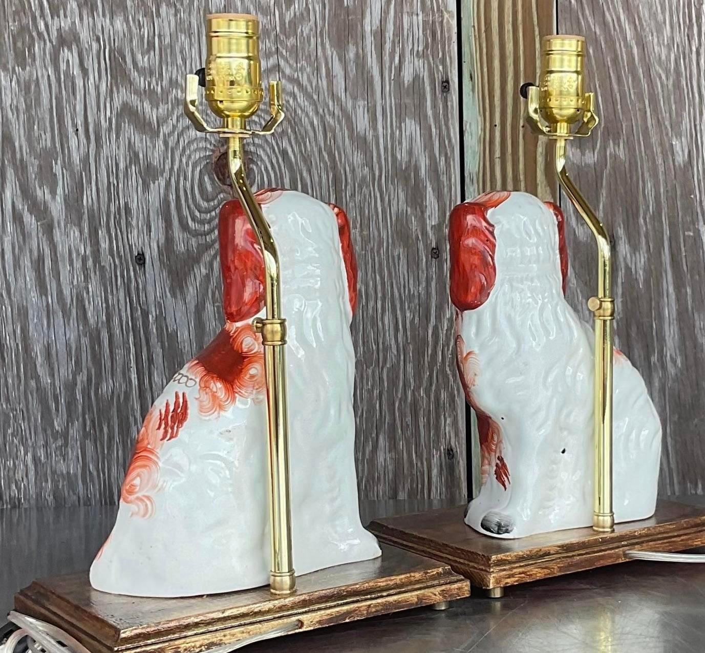 Illuminate your space with this pair of vintage Regency Staffordshire dog table lamps. Melding classic Regency style with American charm, these lamps showcase iconic Staffordshire dog designs, adding a timeless and playful touch to your décor