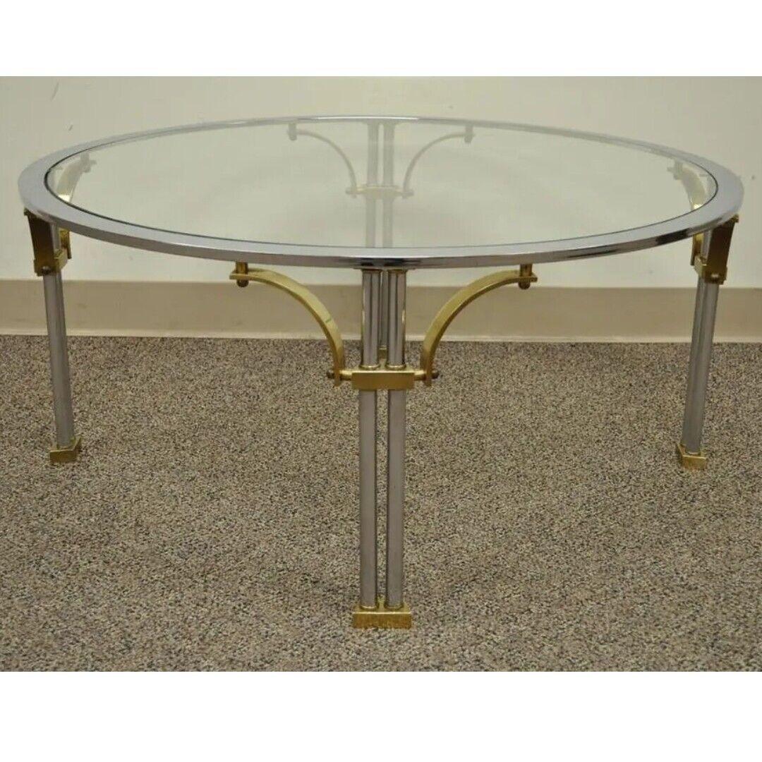 Vintage Regency Style Steel, Brass, Round Glass Coffee Table in the Maison Jansen Style. Item features sleek modernist design, column form legs, brass feet and supports, very nice vintage item. Circa Late 20th Century. Measurements: 16.25