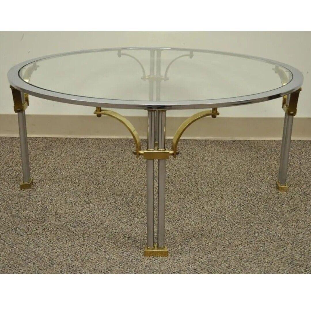 Table basse ronde en acier, laiton et verre de style Vintage Regency dans le style Maison Jansen. Cet article présente un design moderne et élégant, des pieds en forme de colonne, des pieds et des supports en laiton. Il s'agit d'un très bel article