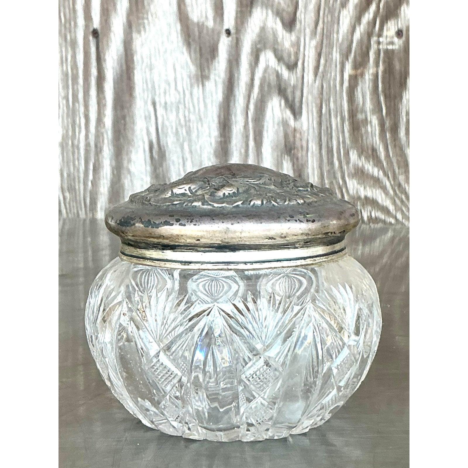 An exquisite blend of refinement and regality, this vintage Regency lidded bowl features brilliant cut crystal paired with a richly detailed sterling silver lid. The intricately pressed floral motif on the sterling top adds Victorian-era elegance,