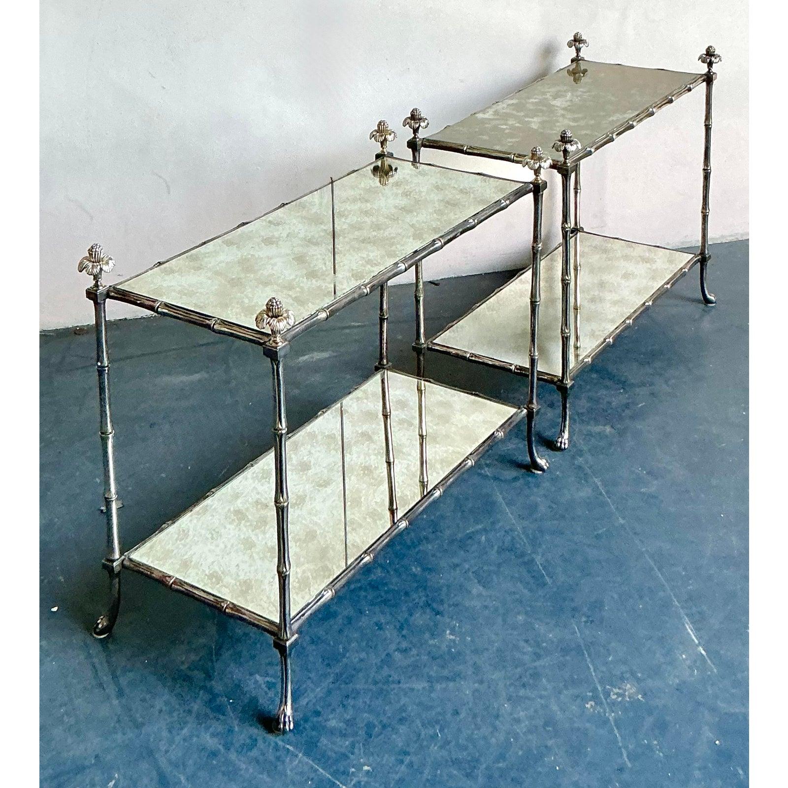 Trasuda chic parigino e glamour hollywoodiano con questa squisita coppia di tavolini étagère vintage nell'iconico stile della Maison Bagues. Le cornici sono magistralmente realizzate in metallo argentato, fuso ad arte per assomigliare a steli di