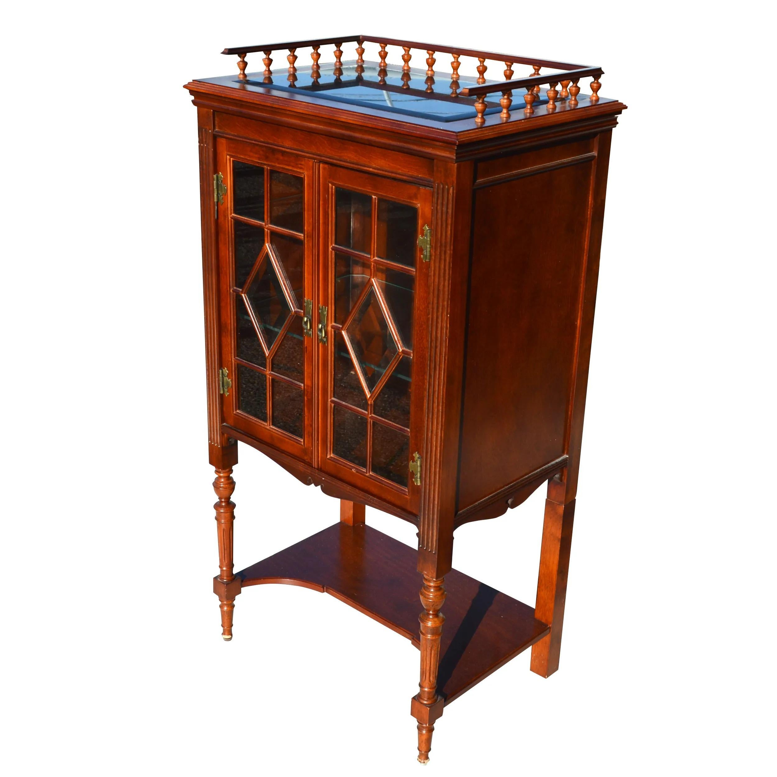 Vintage Regency Style bar cabinet 

Regency style display cabinet or bookcase

Glass fronted with fretwork and glass gallery edged top. Brass hinges and pulls.
Perfect for displaying books and other decorative pieces. Wired for interior