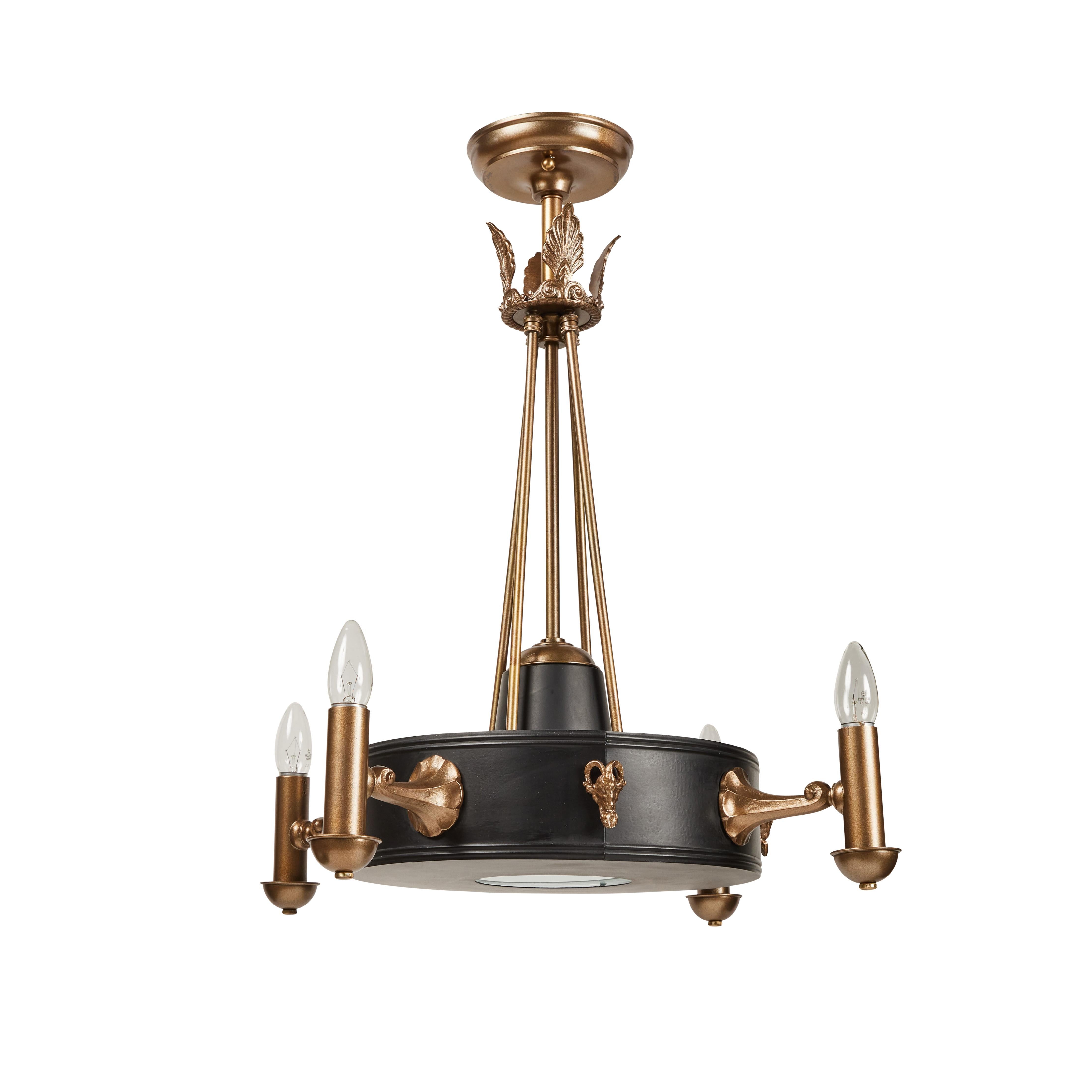 This fixture has been completely restored. The main body has been painted black while all the fittings, arms, canopy and decorative details have been painted in a stately antique brass finish. It has 4 lighted arms and an interior light source in