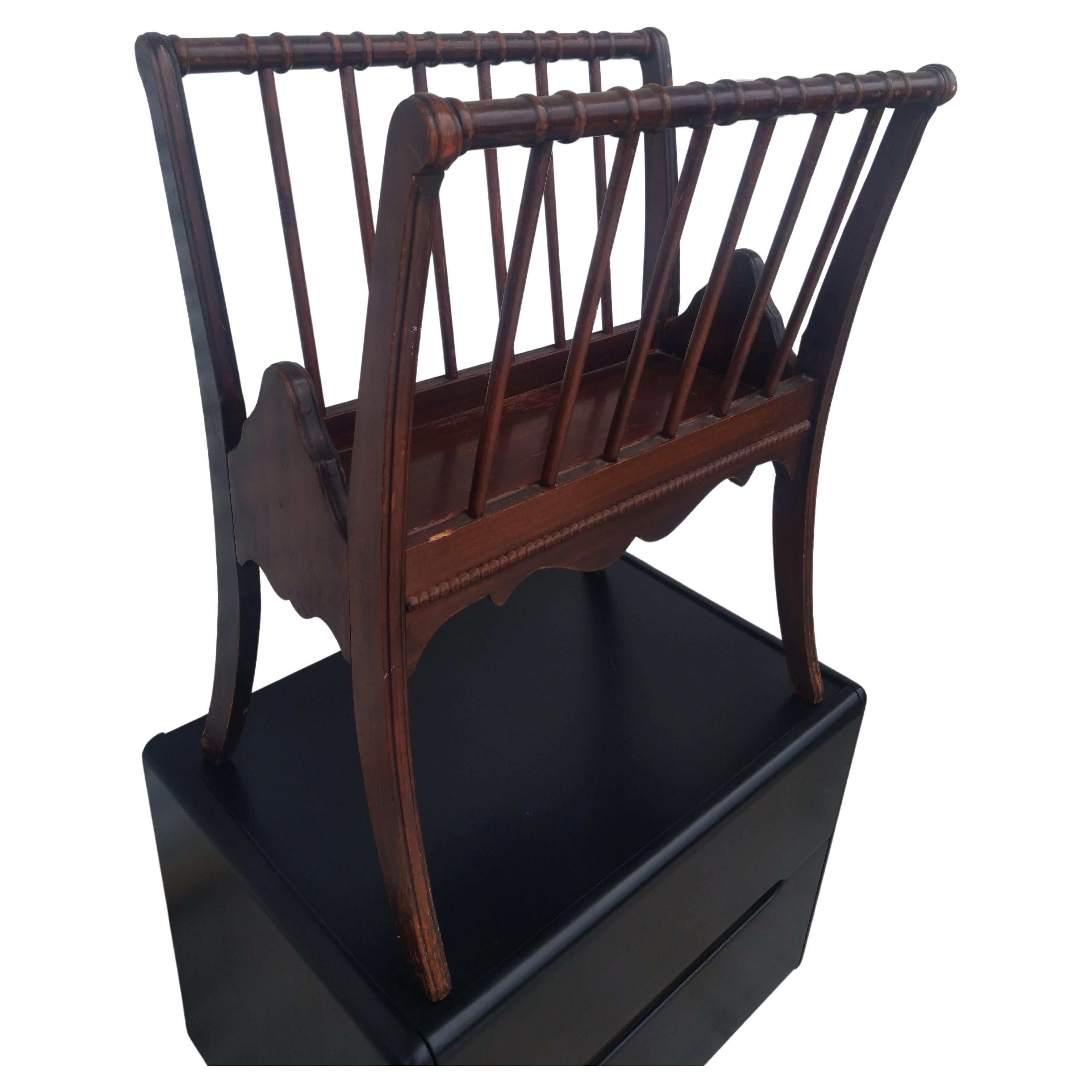 This is nice large size magazine rack. It dates back to the 40's and is made of mahogany. It's has spindles sides and a beaded edge. It bowed construction gives it a sculptural look that an eye catcher.