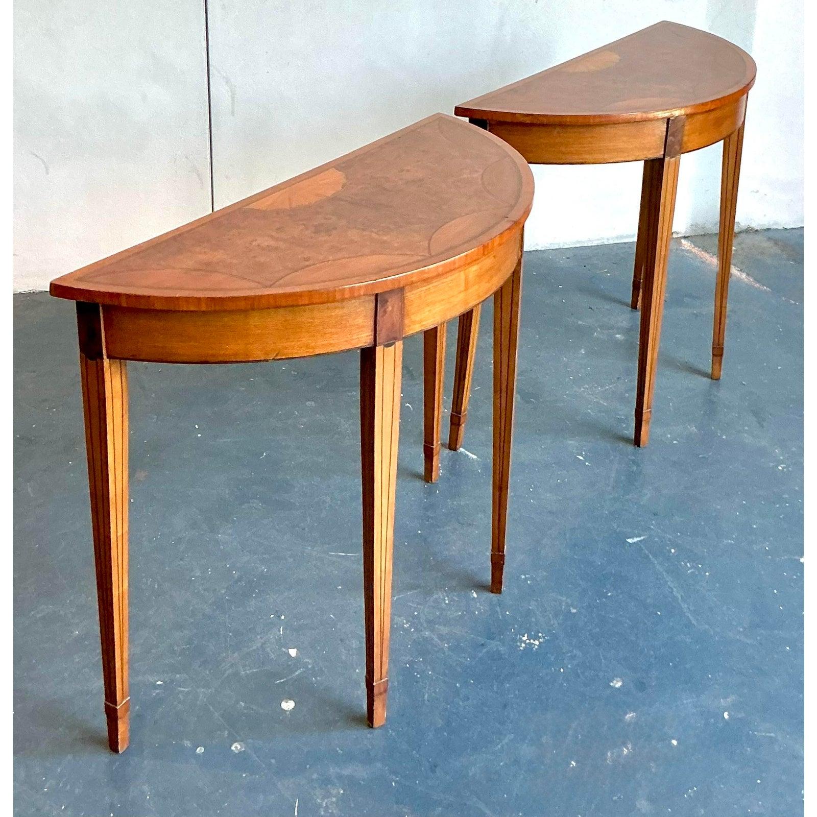 Insufflez à votre intérieur la grâce intemporelle de l'ère néoclassique avec cette exquise paire de tables demilune de style Regency. Chaque table est dotée d'un superbe plateau en ronce de bois, orné d'une marqueterie de rayons de soleil et d'une