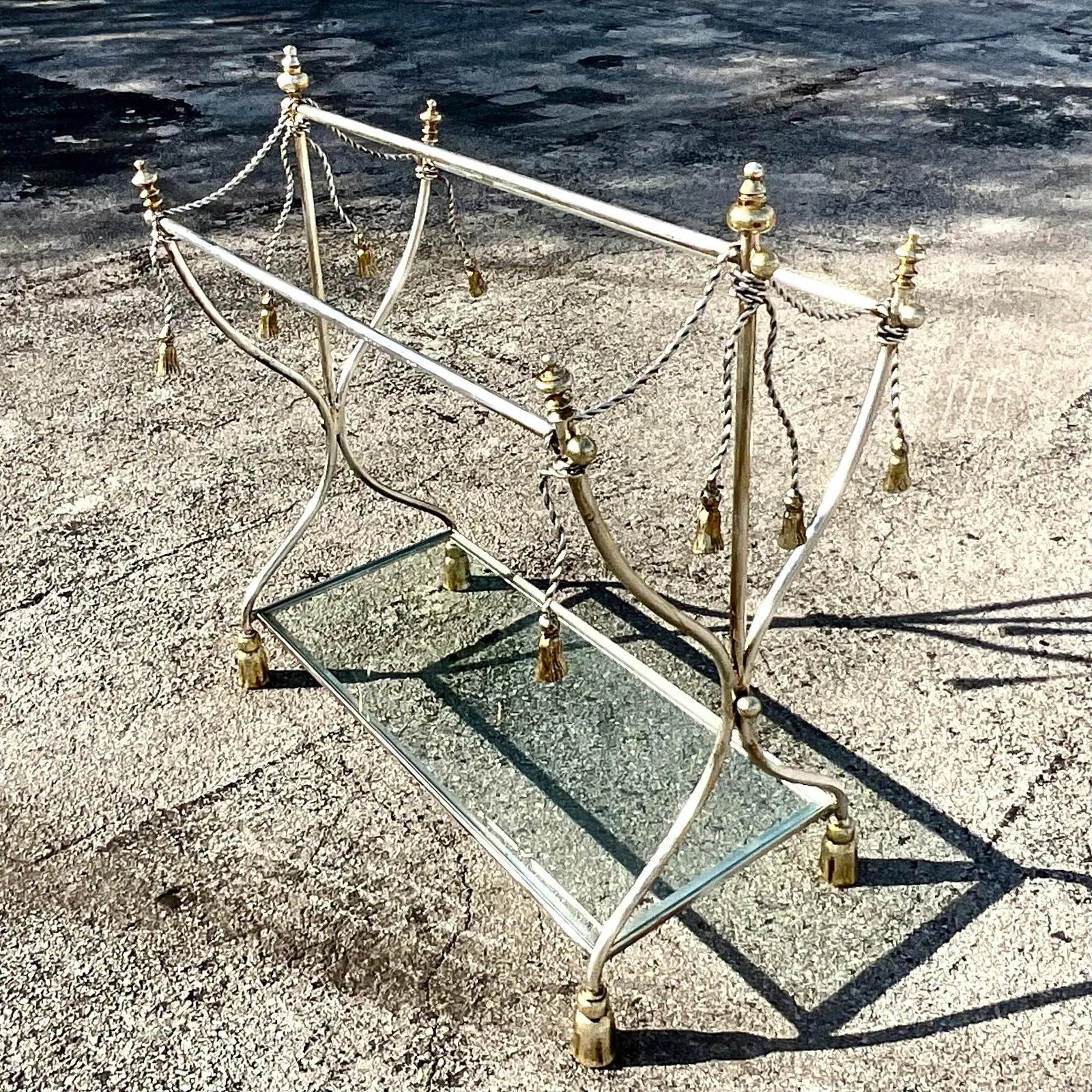 A stunning vintage Regency blanket rack. Chic polished chrome with brass accents. Glamorous swag design with twisted cable and tassels. Lower glass shelf. Acquired from a Palm Beach estate. 
