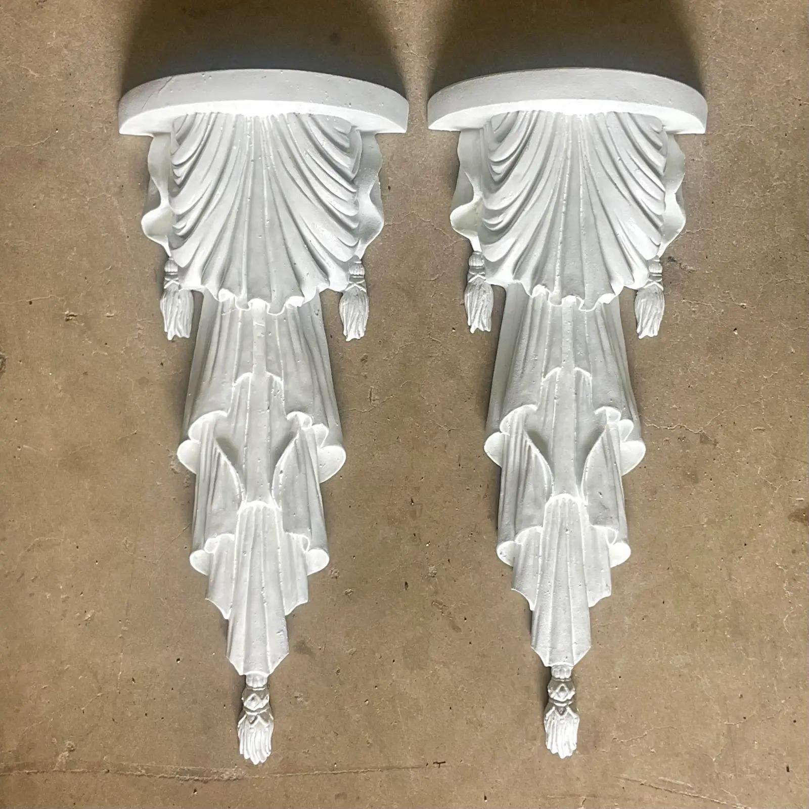 A fabulous pair of vintage Regency wall brackets. Beautiful swag design with a bright white finish. Acquired from a Palm Beach estate.