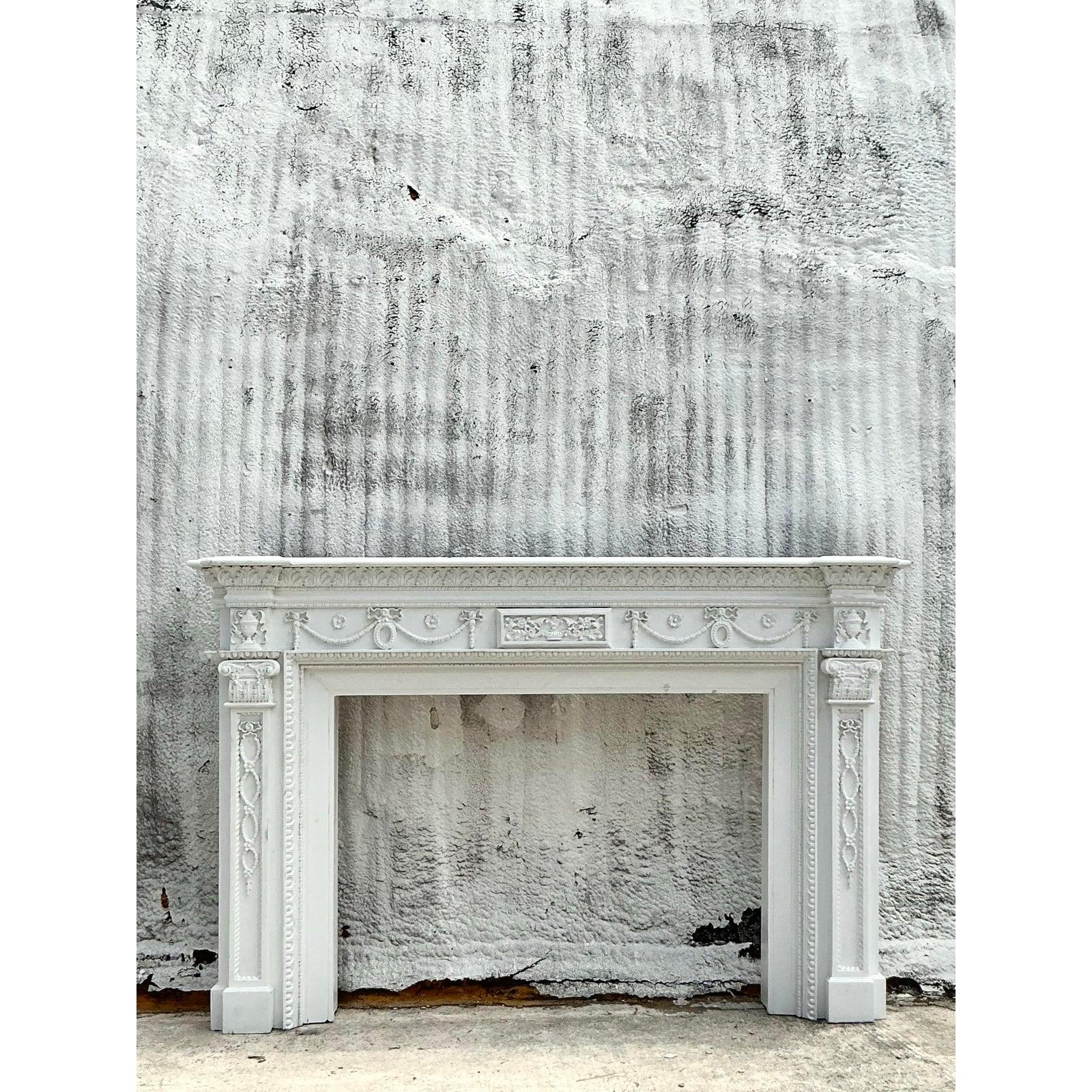 Élevez votre foyer grâce à l'élégance intemporelle de cet habillage de cheminée vintage de style Regency. Fabriqué avec un grand souci du détail, il présente des sculptures ornementales, notamment des guirlandes classiques, des rosettes et des