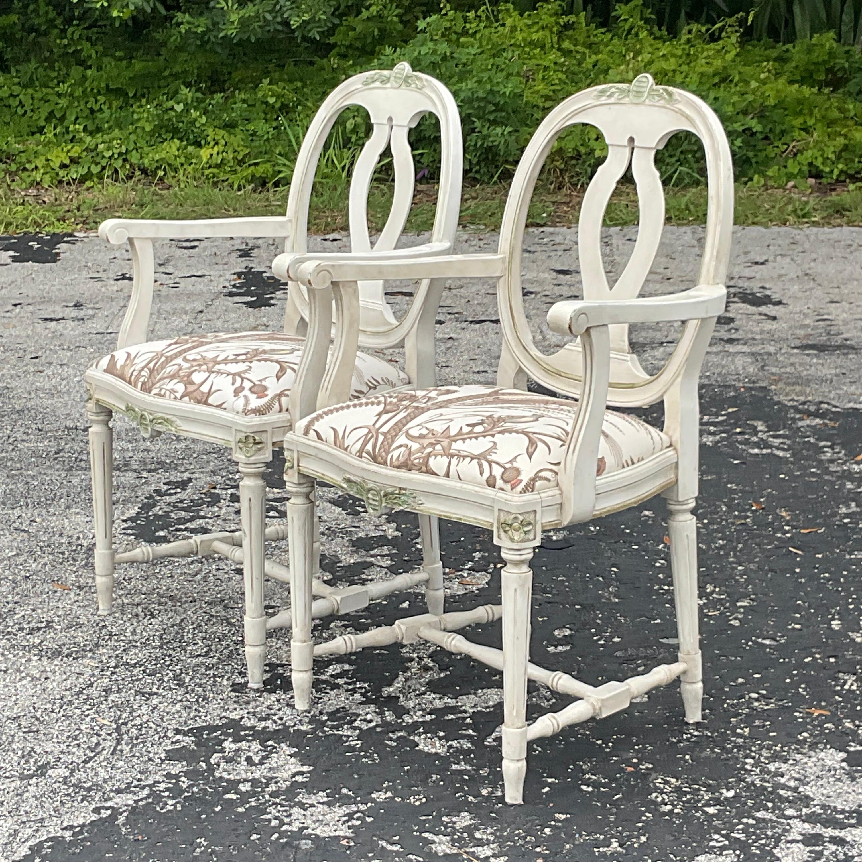 A vintage pair of Regency arm chairs. A chic Swedish Gustavian design with gorgeous hand carved detail. Upholstered in a classic Schumacher Botanical print. Acquired from a Palm Beach estate.