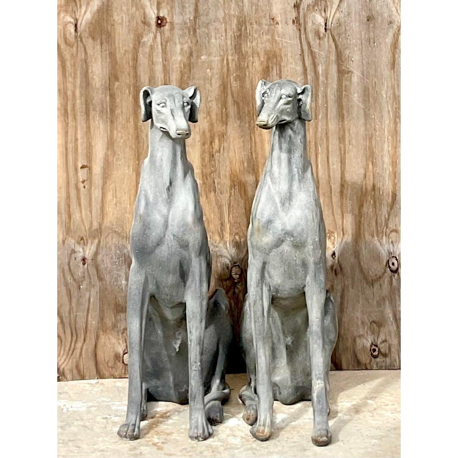 Fantastic pair of vintage Regency dogs. Slender and regal pair of Greyhounds with a chic charcoal finish. Tiny flashes of metallic peeking through. Made from a cast ceramic with a textured matte finish. Acquired from a Palm Beach estate.
