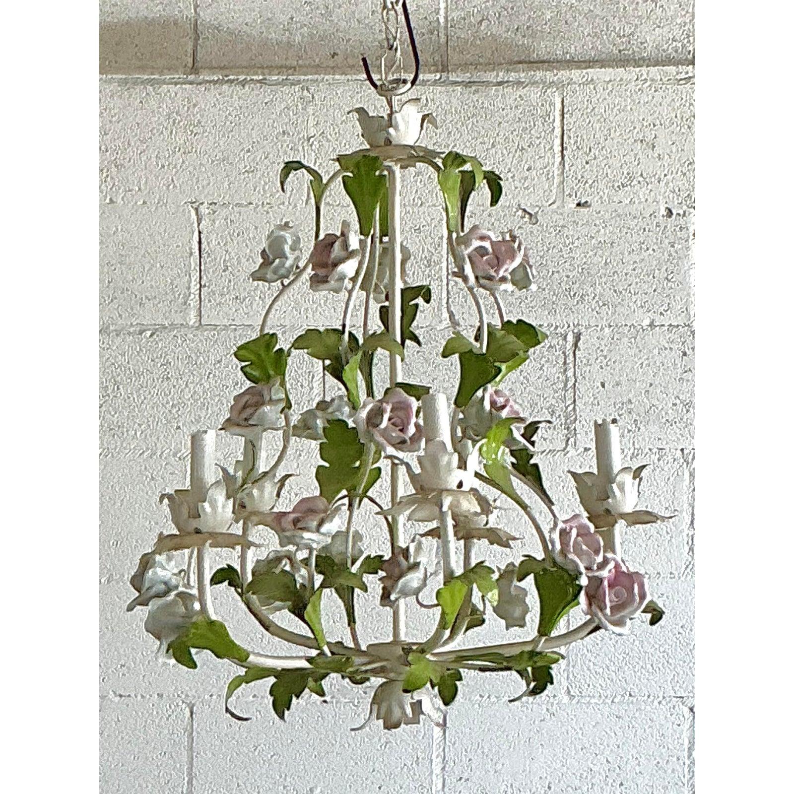 Illumina il tuo spazio con il fascino romantico di questo squisito lampadario vintage a tole. Esempio magistrale di design Hollywood Regency, questo apparecchio presenta una delicata cascata di foglie di metallo dipinte a mano e intrecciate con rose