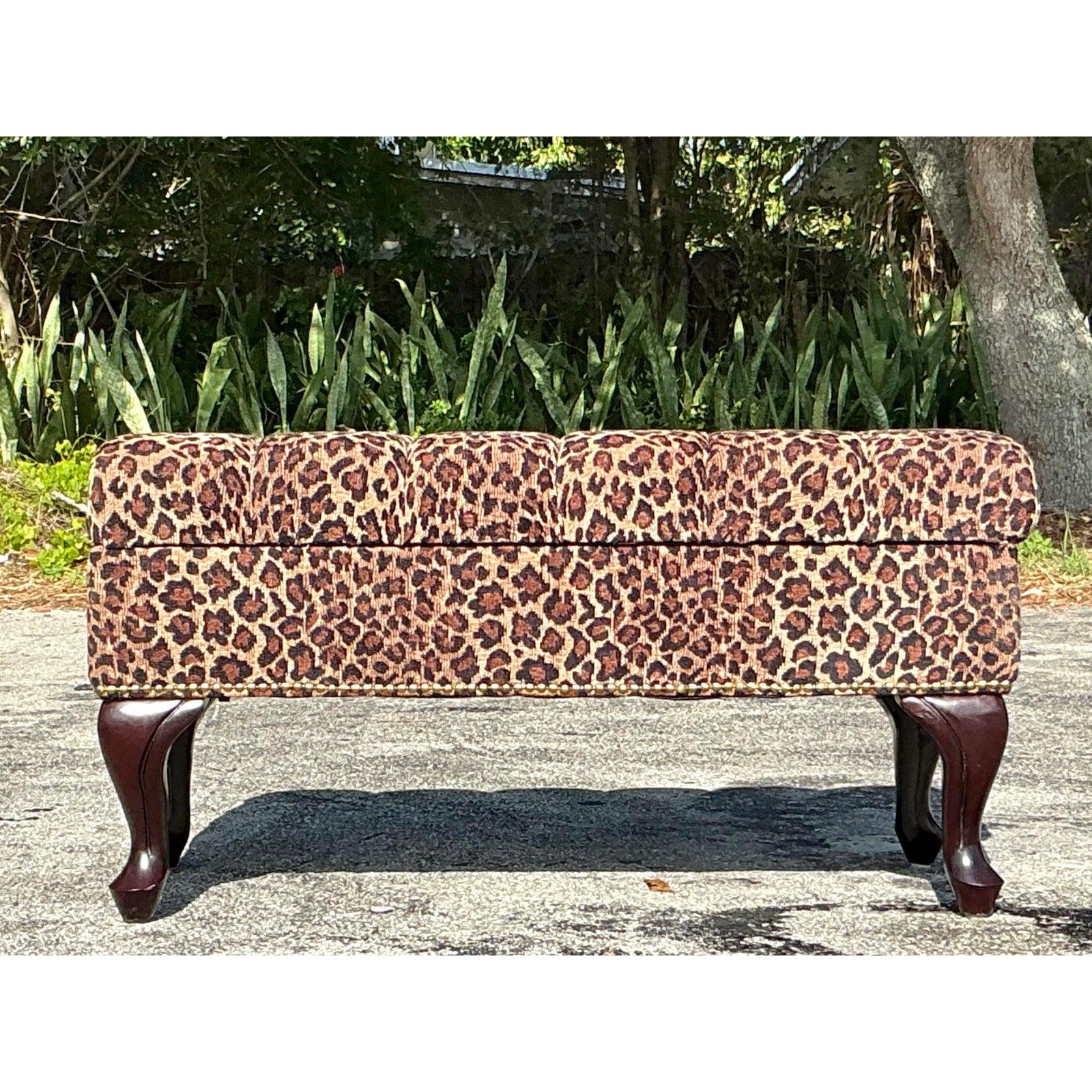 Make a bold statement with this glamorous Vintage Regency Tufted Leopard Ottoman Bench. Featuring richly tufted cushioning wrapped in a striking leopard print fabric, this bench exudes both opulence and playfulness. The classic Regency-style