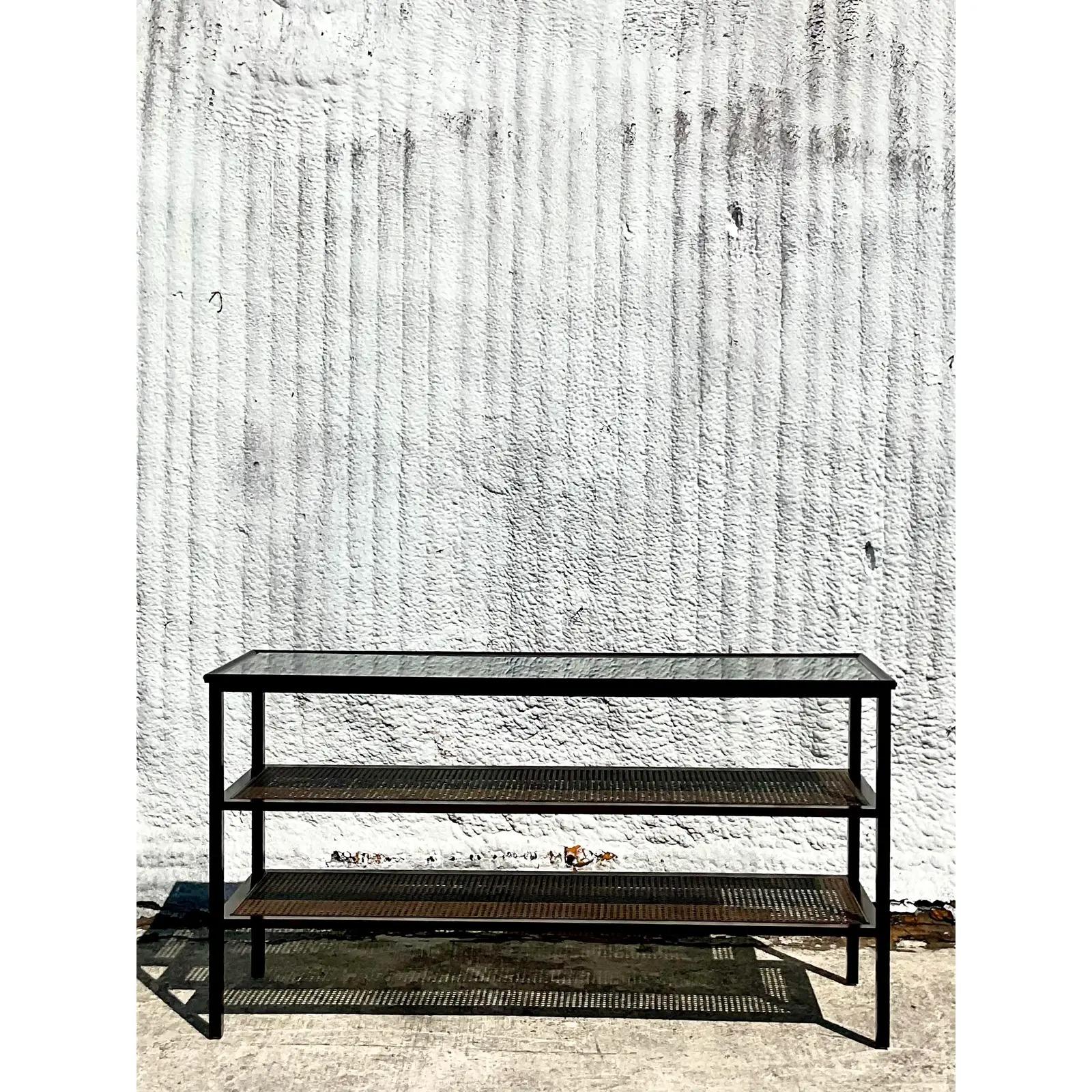 Fantastic vintage console table. Beautiful two tier frame with inset cane panels and glass shelves. Acquired from a Palm Beach estate.