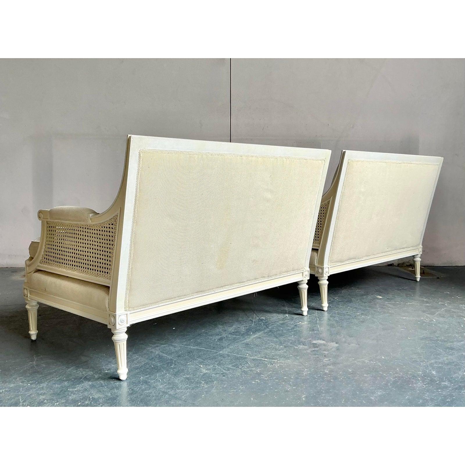 Indulge in timeless elegance with this exquisite pair of vintage Hollywood Regency settees, perfect for adding a touch of sophisticated charm to any refined interior. Each settee showcases classic Regency lines, featuring a beautifully crafted
