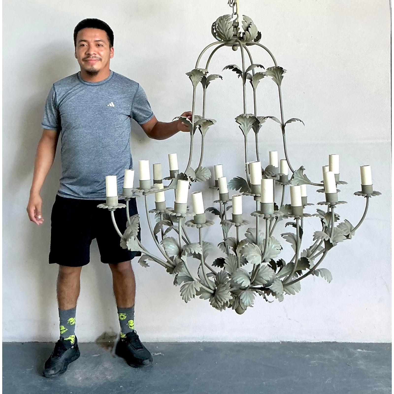 This monumental vintage chandelier, reminiscent of classic designs by Vaughan, is a breathtaking piece that combines botanical elegance with the sophisticated drama of the Hollywood Regency style. Its grand scale and intricate, hand-wrought foliate