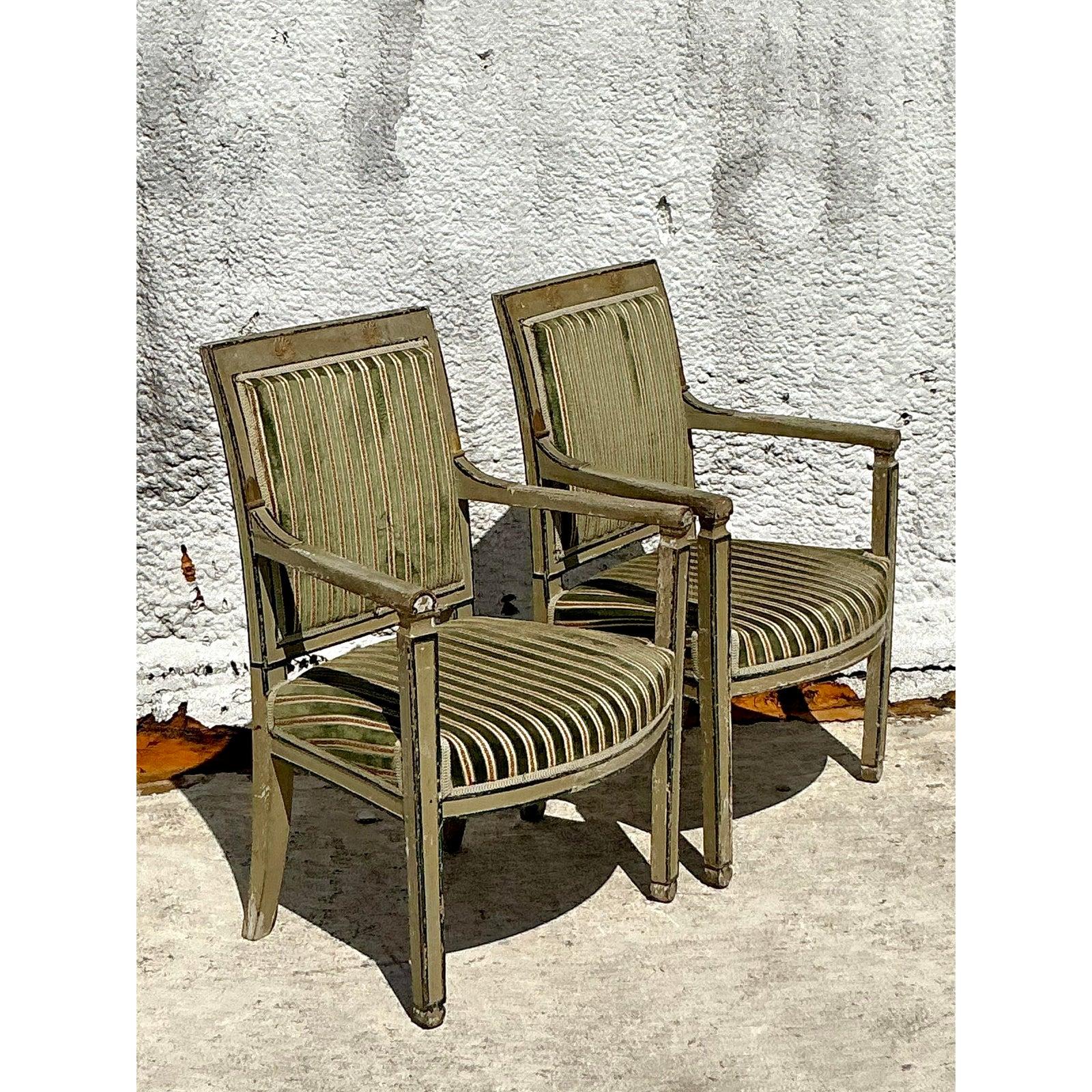 Scopri una coppia di squisite sedie fauteuil vintage che racchiudono l'eleganza senza tempo dello stile Regency con un delizioso tocco contemporaneo. Queste sedie sono caratterizzate da una classica struttura in legno, rifinita ad arte con una