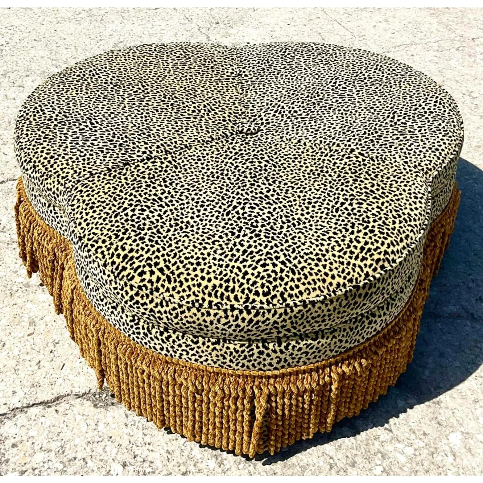 Fantastic vintage Regency ottoman. Beautiful clover leaf shape covered in a velveteen leopard. A thick twisted fringe runs along the bottom. Perfect as an ottoman or glamorous coffee table. You decide! Acquired from a Naples estate.