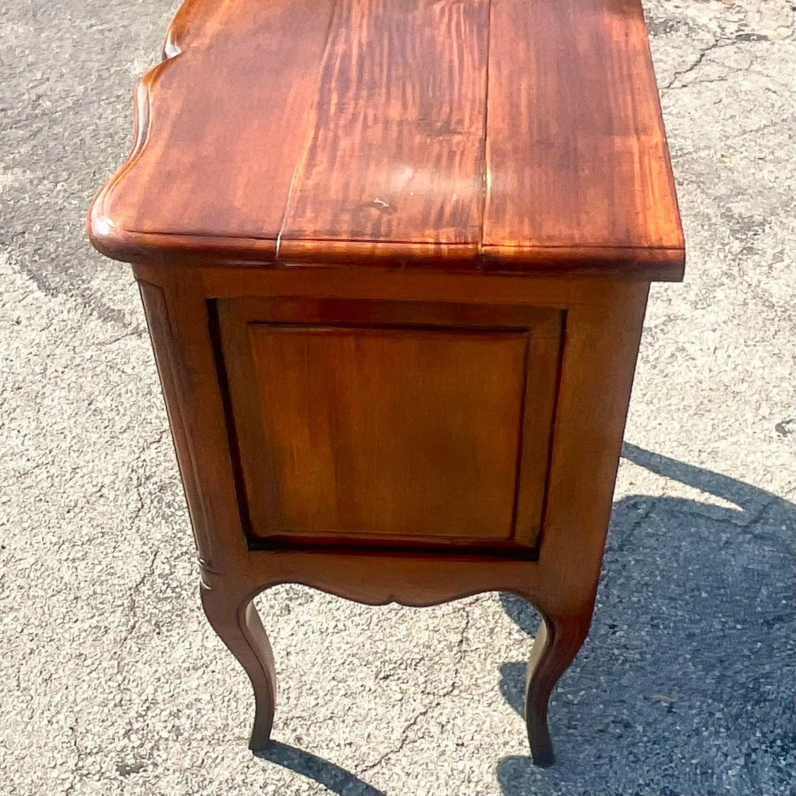 A fantastic vintage Regency chest of drawers. A beautiful wave front design with heavy brass hardware. Acquired from a Palm Beach estate.