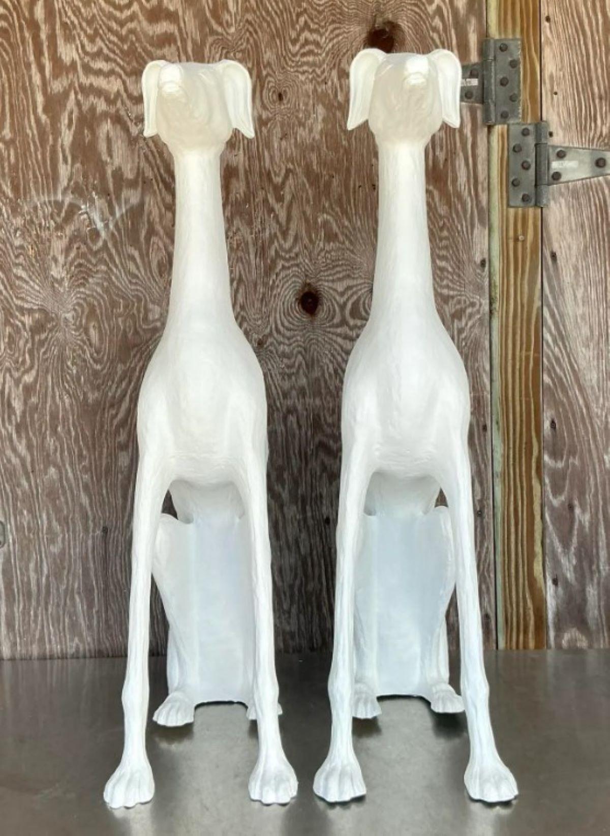 Eleva i tuoi interni con questa straordinaria coppia di cani in gesso bianco Vintage Regency, un duo scultoreo che emana un fascino e un'eleganza senza tempo. Queste figure snelle e aggraziate, con i loro colli allungati e la loro forma stilizzata,