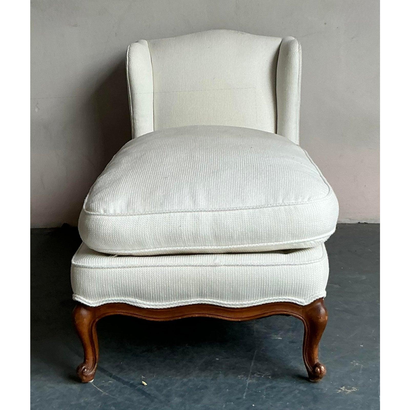 Entdecken Sie einen zeitlosen Rückzugsort mit dieser eleganten Chaiselongue im Vintage-Stil. Dieses meisterhaft gestaltete Möbelstück weist die klassische, schützende Silhouette einer hohen Rückenlehne auf und bietet einen gemütlichen und
