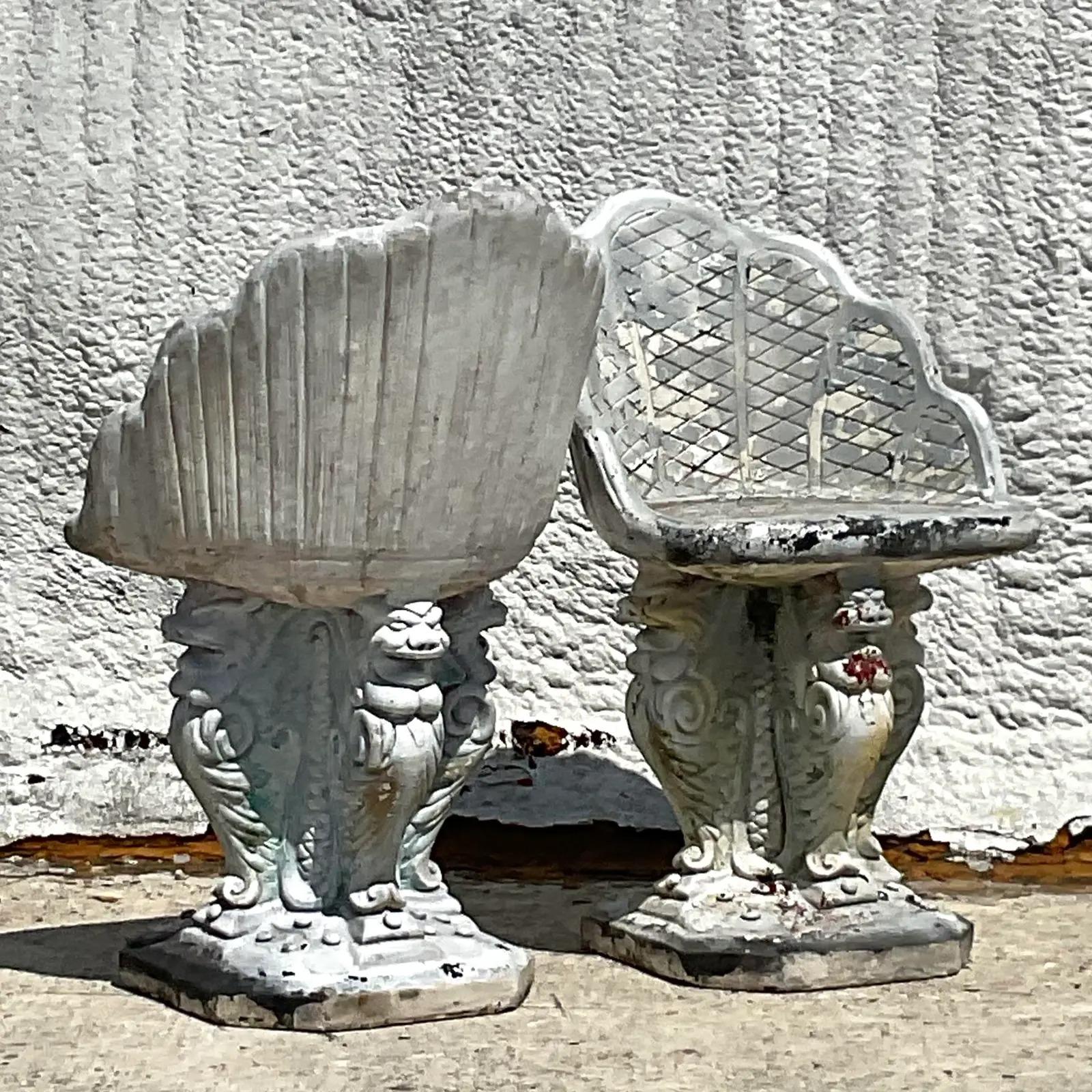 An extraordinary pair of vintage Regency cement chairs. The coveted Grotto design with lots of chic detail. The shell back chair rests on handsome winged griffins. Lots of great patina from time. Perfect as is or give them a coat of fresh paint to