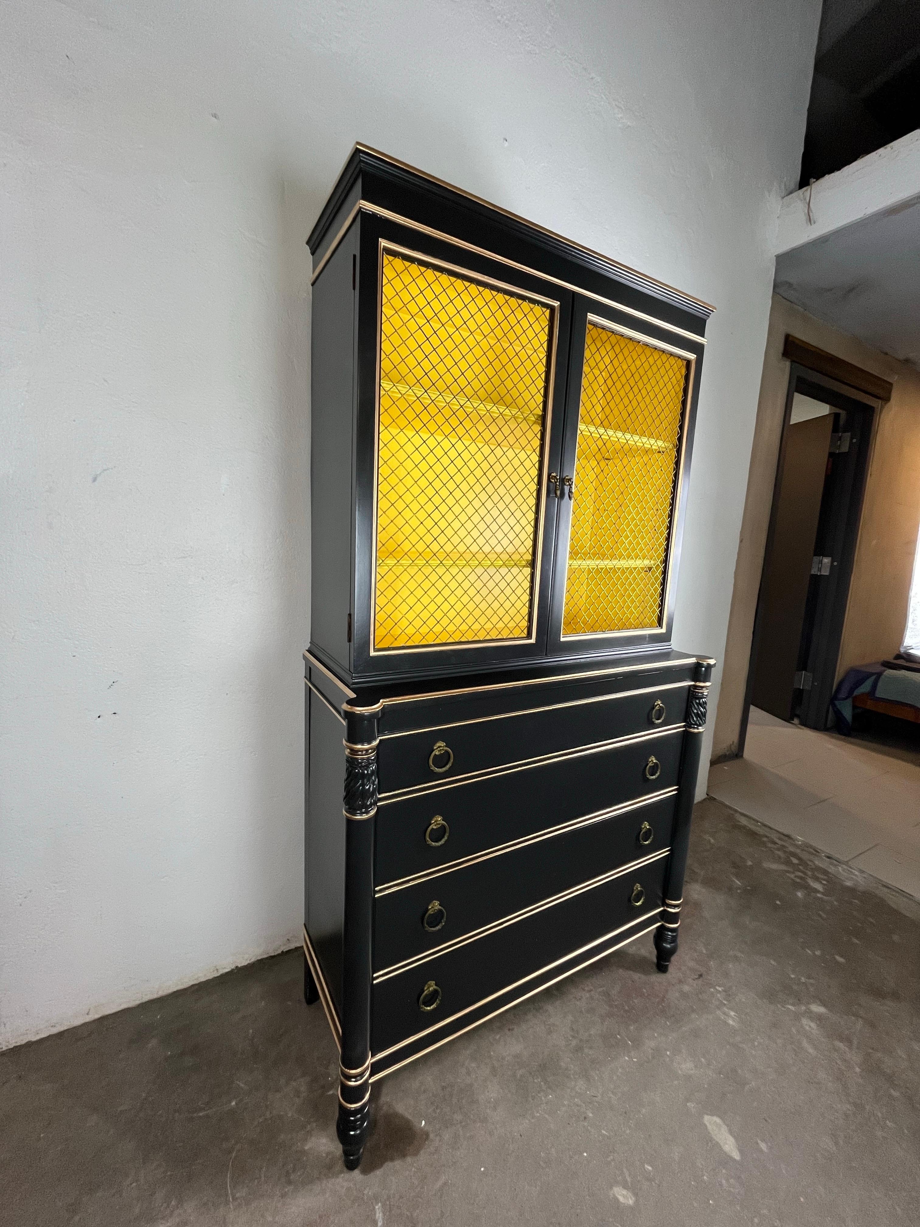 Fantastique cabinet Regency peint d'époque. Magnifique armoire peinte avec des portes en grillage glamour. Peint en noir riche avec un intérieur jaune, il donne à cette pièce un aspect très glamour. Beaucoup d'espace de rangement en dessous. 