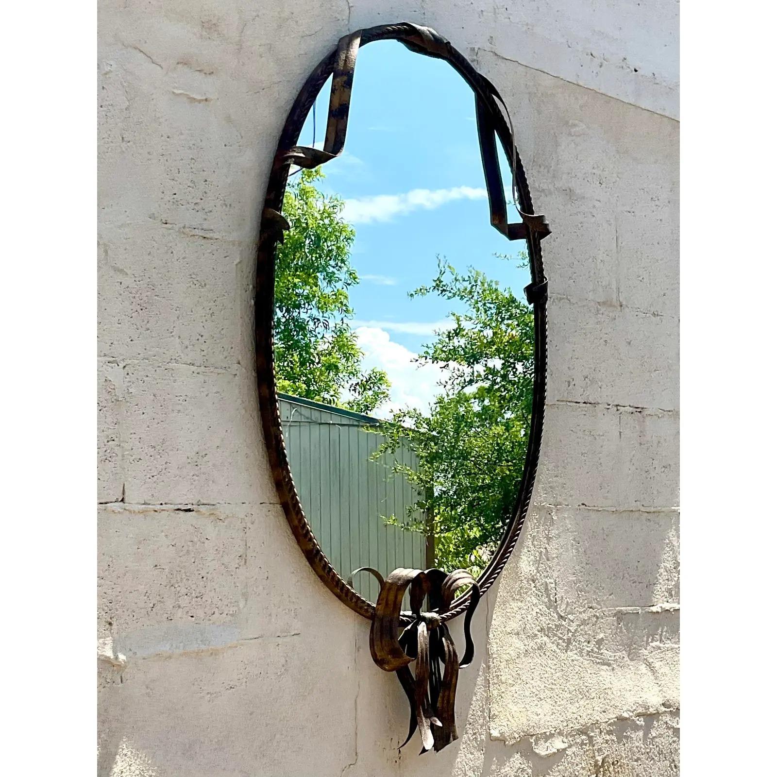 Vintage Regency wall mirror. Beautiful wrapped bow design in a chic distressed finish. Acquired from a Palm Beach estate.
