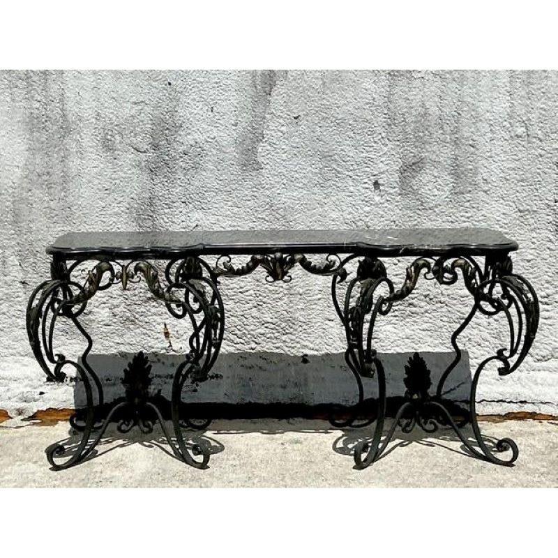 Command attention with this grand Vintage Regency Wrought Iron Console Table, a magnificent piece that seamlessly blends robust craftsmanship with opulent design. This substantial console features an intricately hand-forged wrought iron base,