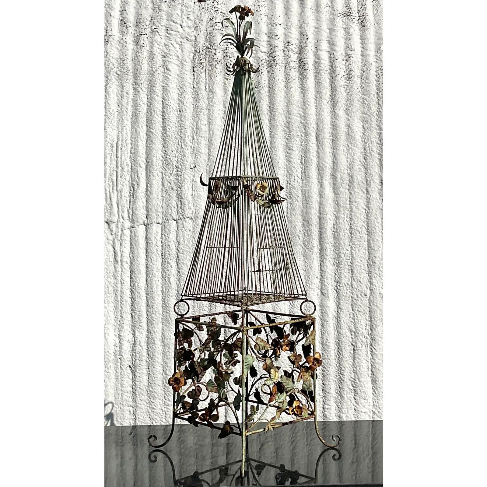 An incredible vintage Regency birdcage. Wrought iron frame with beautiful attention to detail. All over floating flowers and vintage. Gorgeous patina from time gives it a real period look. Acquired from a Palm Beach estate.

The birdcage is in great