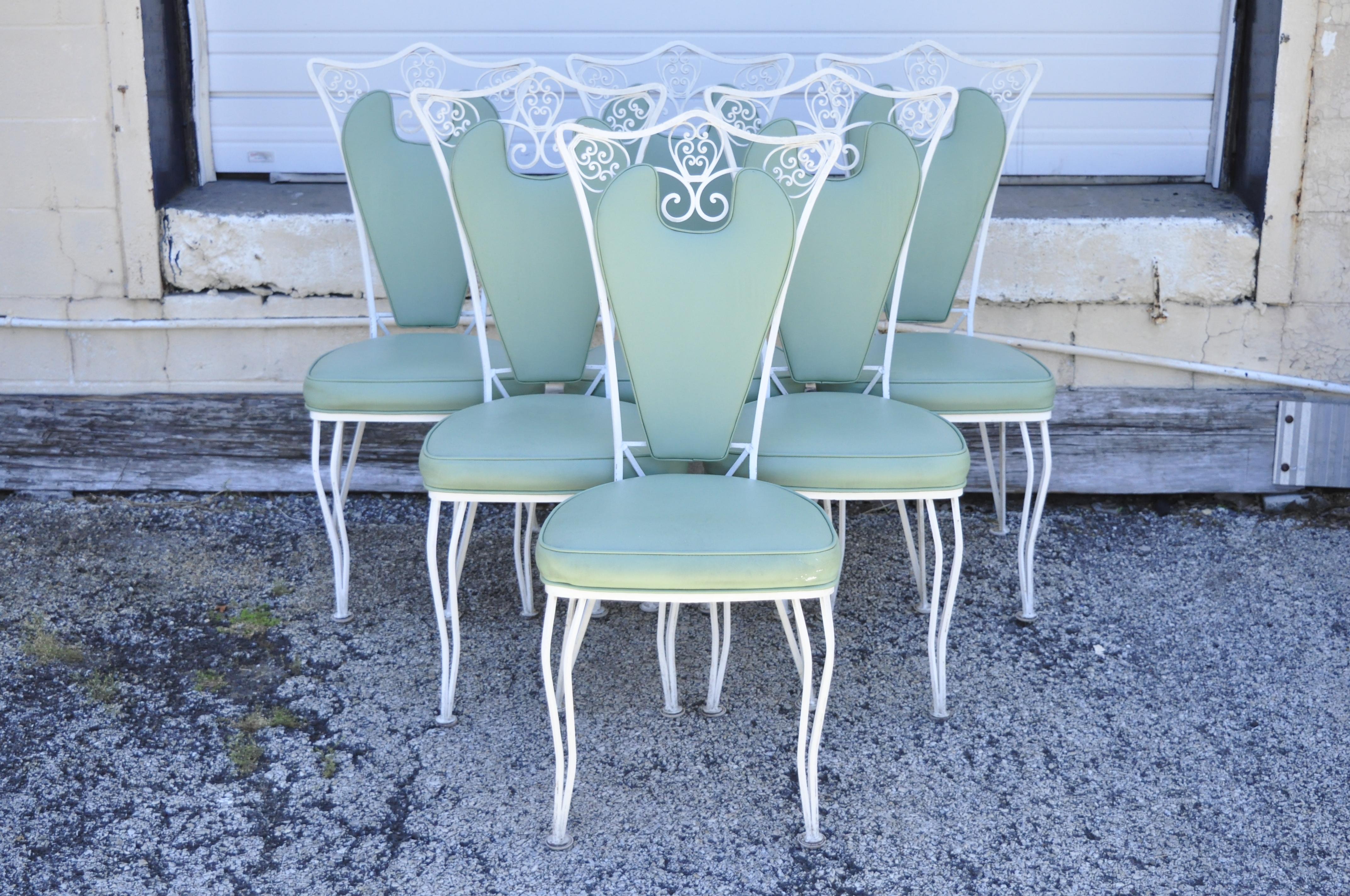 Vintage Regency wrought iron dining set oval table 6 chairs mint green vinyl - 7pc set. Item features (6) dining side chairs, mint green vinyl upholstery, wrought iron frames, oval laminate top table with pedestal base, wrought iron construction.