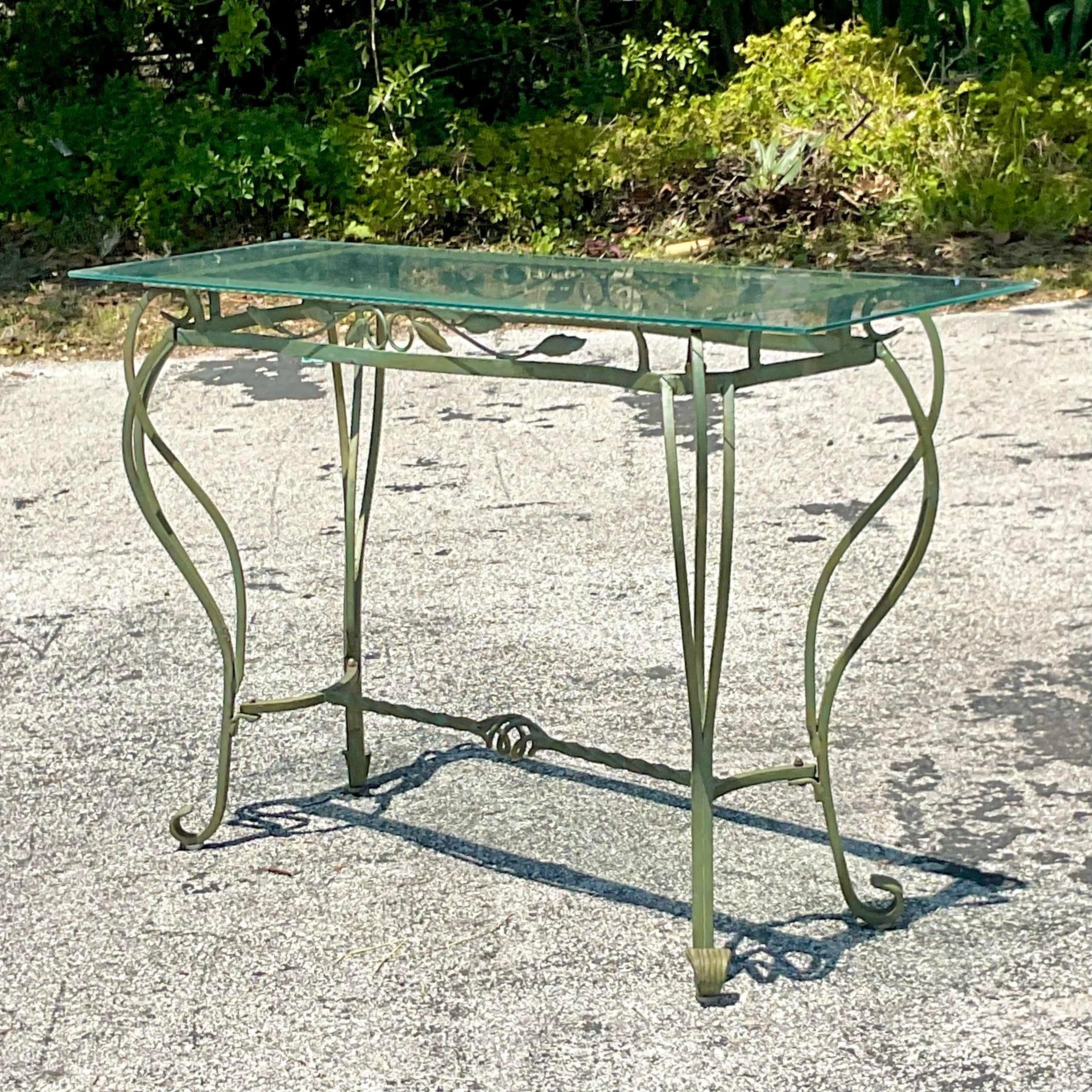 Introducing our Vintage Regency Wrought Iron Leaf Console Table, a graceful fusion of nature-inspired design and American craftsmanship. Crafted with intricate leaf motifs and sturdy wrought iron, this table exudes timeless elegance while seamlessly