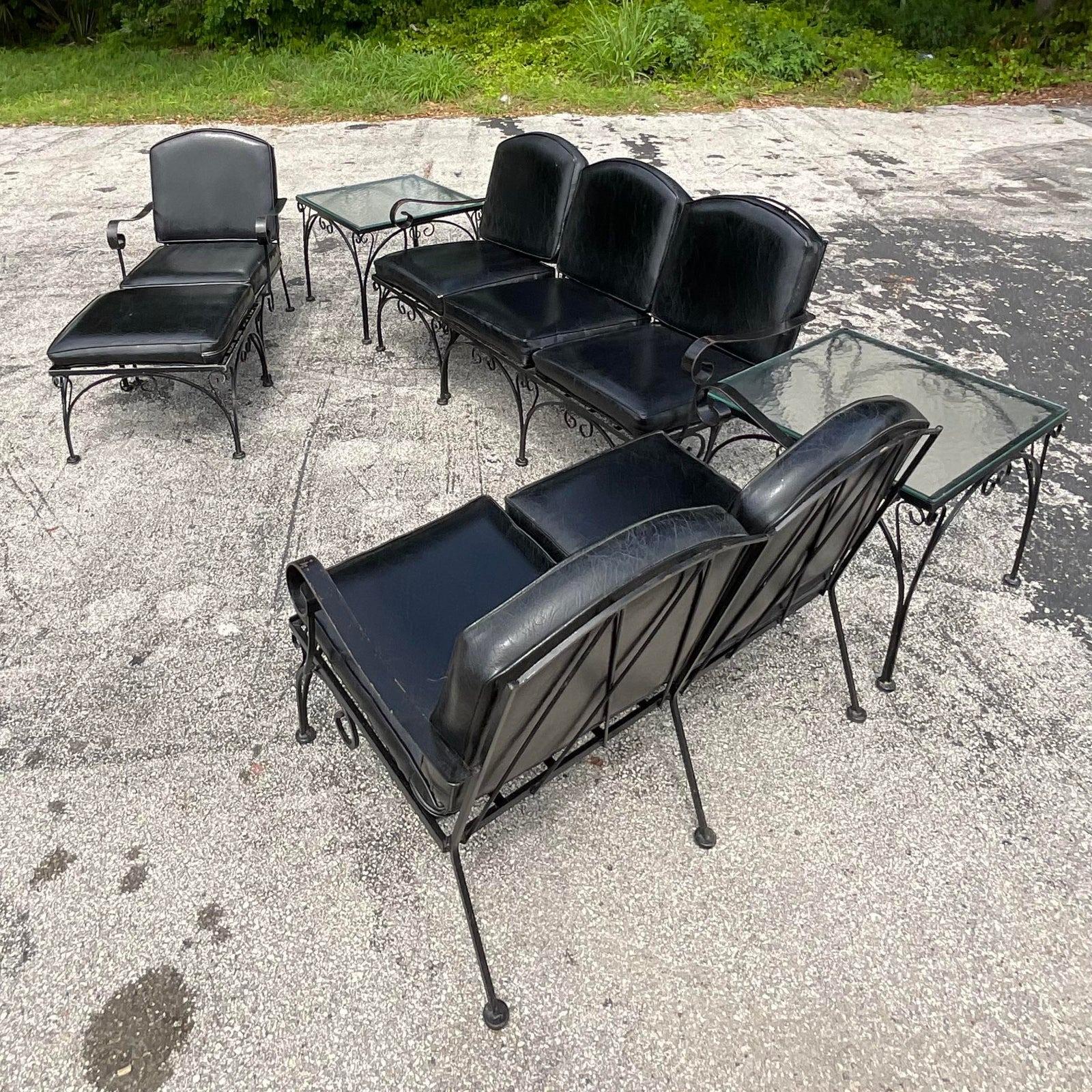 A fantastic vintage Regency outdoor patios set. Chic wrought iron in a gloss black finish. Coordinating cushions in a faux leather. Sofa, loveseat, lounge chair and ottoman and two side tables. The works! Acquired from a Palm Beach estate.

Sofa