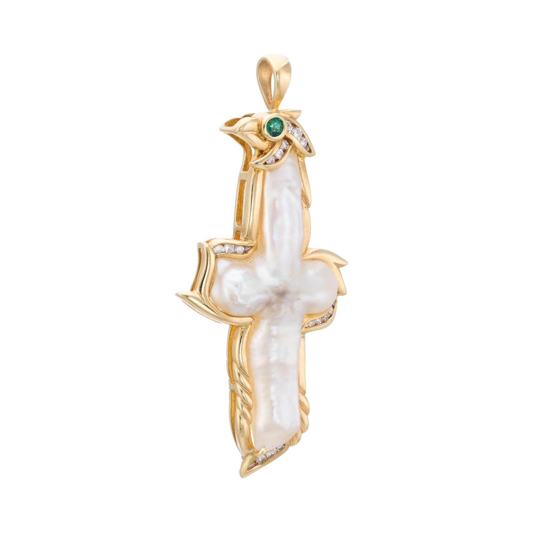 Finely detailed religious cross pendant, crafted in 18 karat yellow  gold.  

A large Biwa pearl measures 41mm x 20mm, accented with an estimated 0.33 carats of diamonds (estimated at G-H color and VS2-SI1 clarity). The emerald is estimated at 0.05