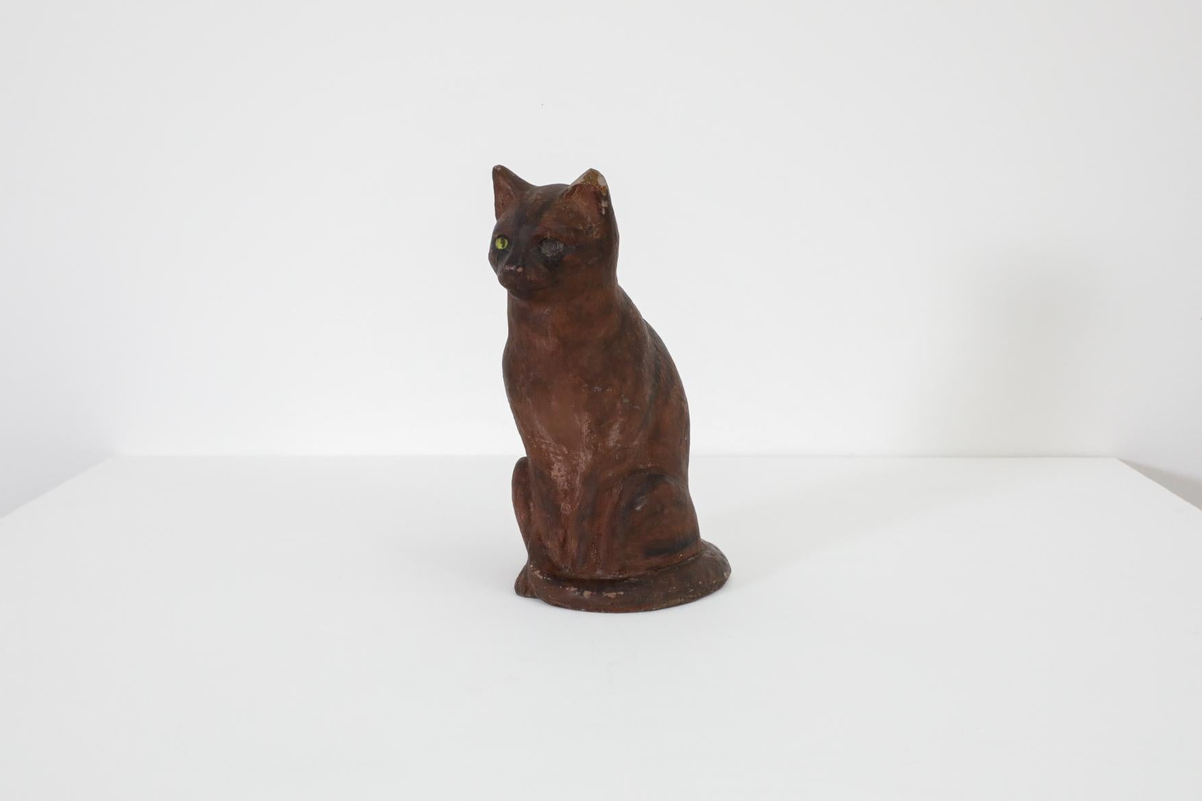 Rembrandt Bugatti Style decorative statuette of a sitting poised cat. Fabulous door stop or entryway mascot that tugs at your heart with it's missing eye, poor thing! Painted cement with a lovely deep patina and some chipping. Weighs approximately