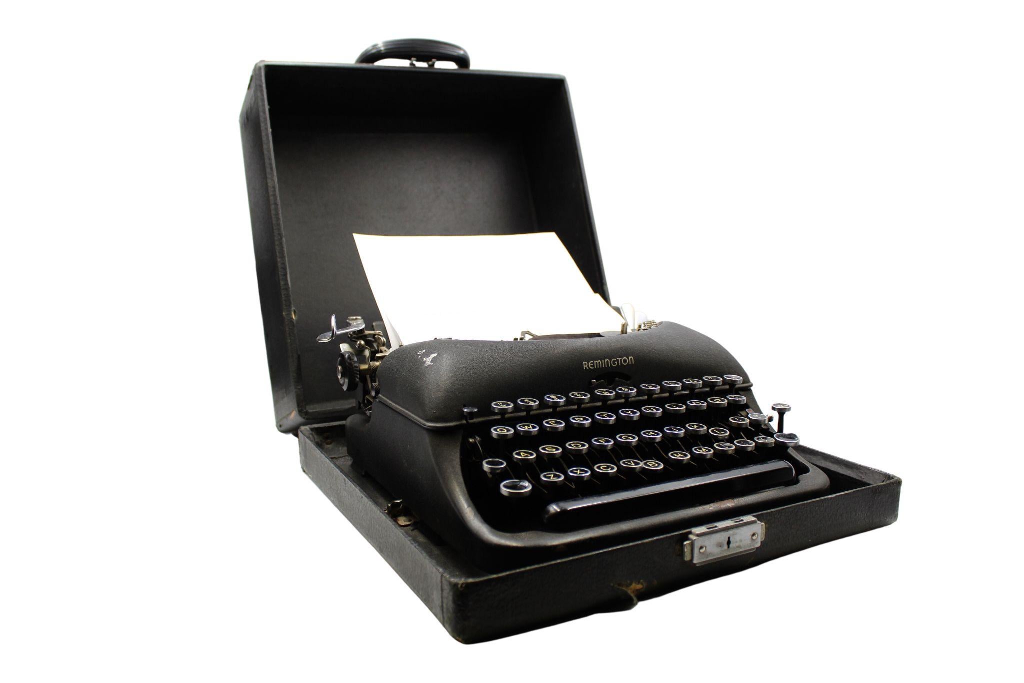 Presented is a vintage Remington Rand typewriter from 1947.  The typewriter is the portable De Luxe Model 5, issued in a sleek carrying case. Still functional, this classic design features a black crinkle finish, and a QWERTY keyboard. Included in