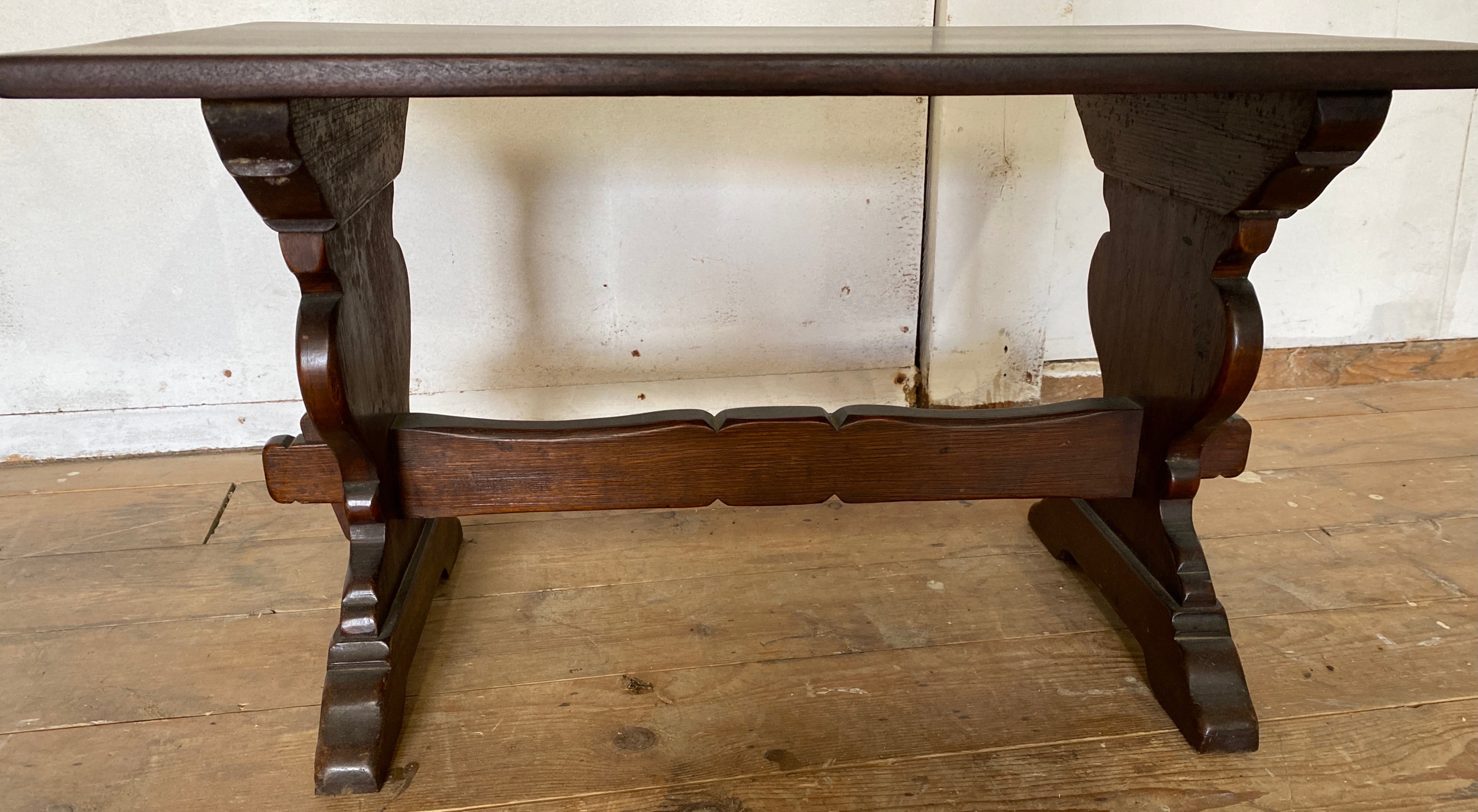 A very handsome Renaissance style wooden bench rests on two shapely base supports connected by a horizontal stretcher. Use it as a coffee table, bench, stool or side table.