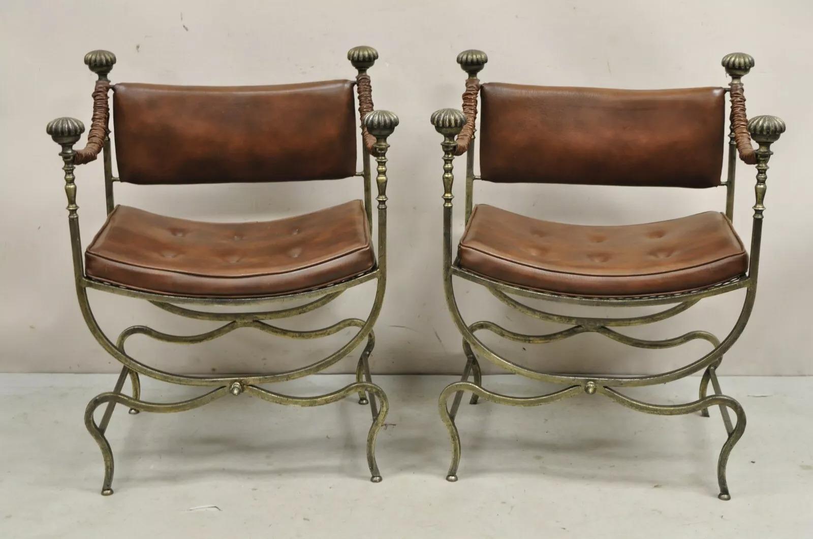 Vintage Renaissance Style Heavy Wrought Iron Savonarola Curule Campaign Arm Chairs with Brown Vinyl Upholstery - a Pair. Circa Mid 20th Century. Measurements: 34