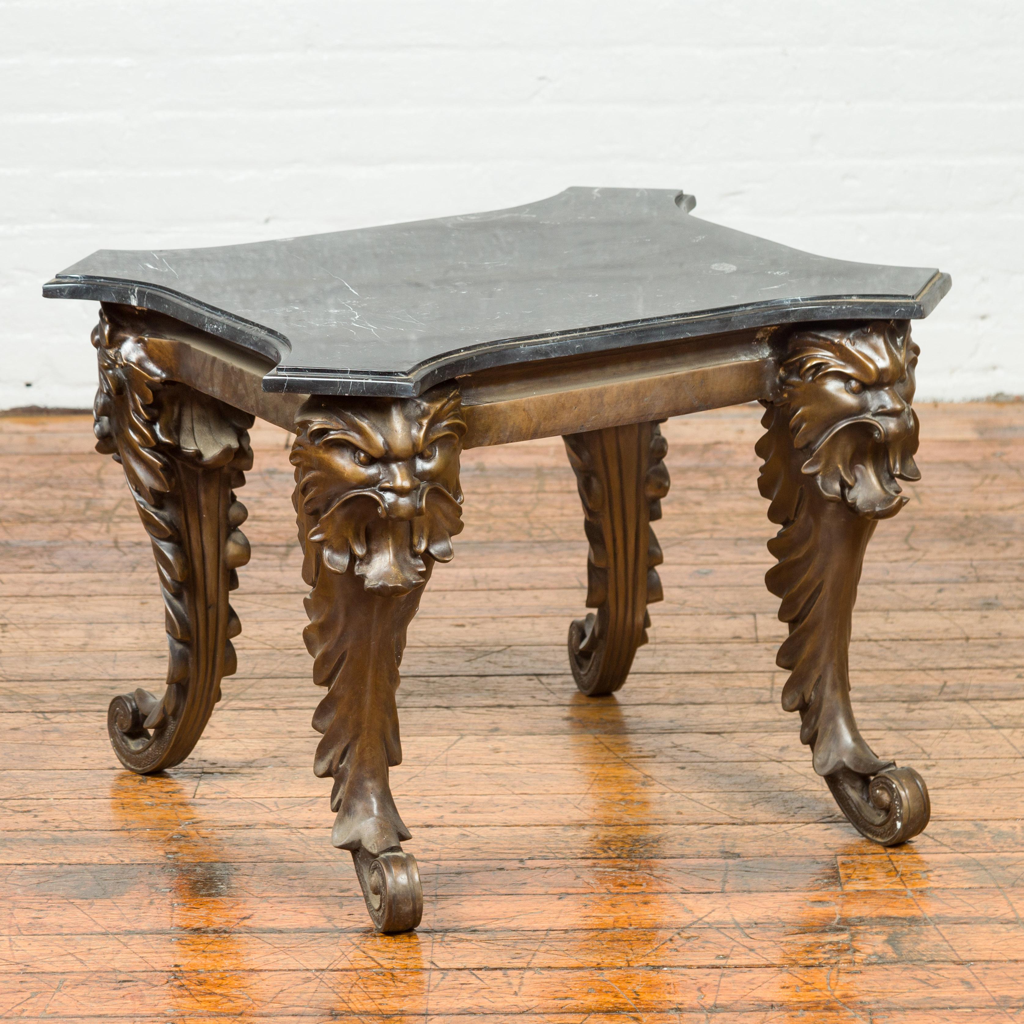 A vintage Renaissance style side table from the mid-20th century with grotesque motifs and black marble top. Created with the traditional technique of the lost-wax (à la cire perdue) that allows a great precision and finesse in the details, this