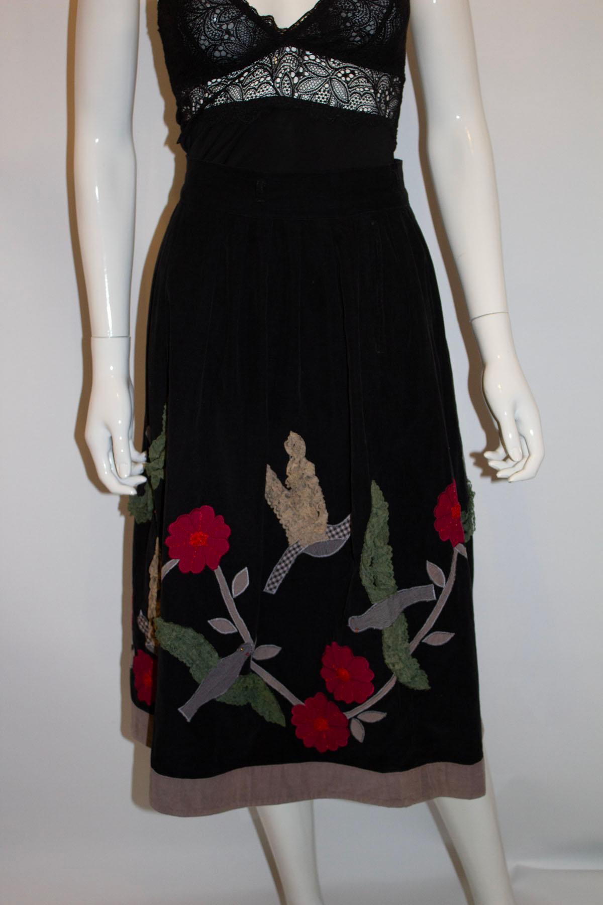 Une jupe vintage amusante de Rene Derhy, Paris, France. La jupe est en courdroy de coton noir avec des cerceaux de ceinture et une ouverture zippée. Elle est décorée d'appliques et n'est pas doublée.  Mesures : taille 25'', longueur 29''.