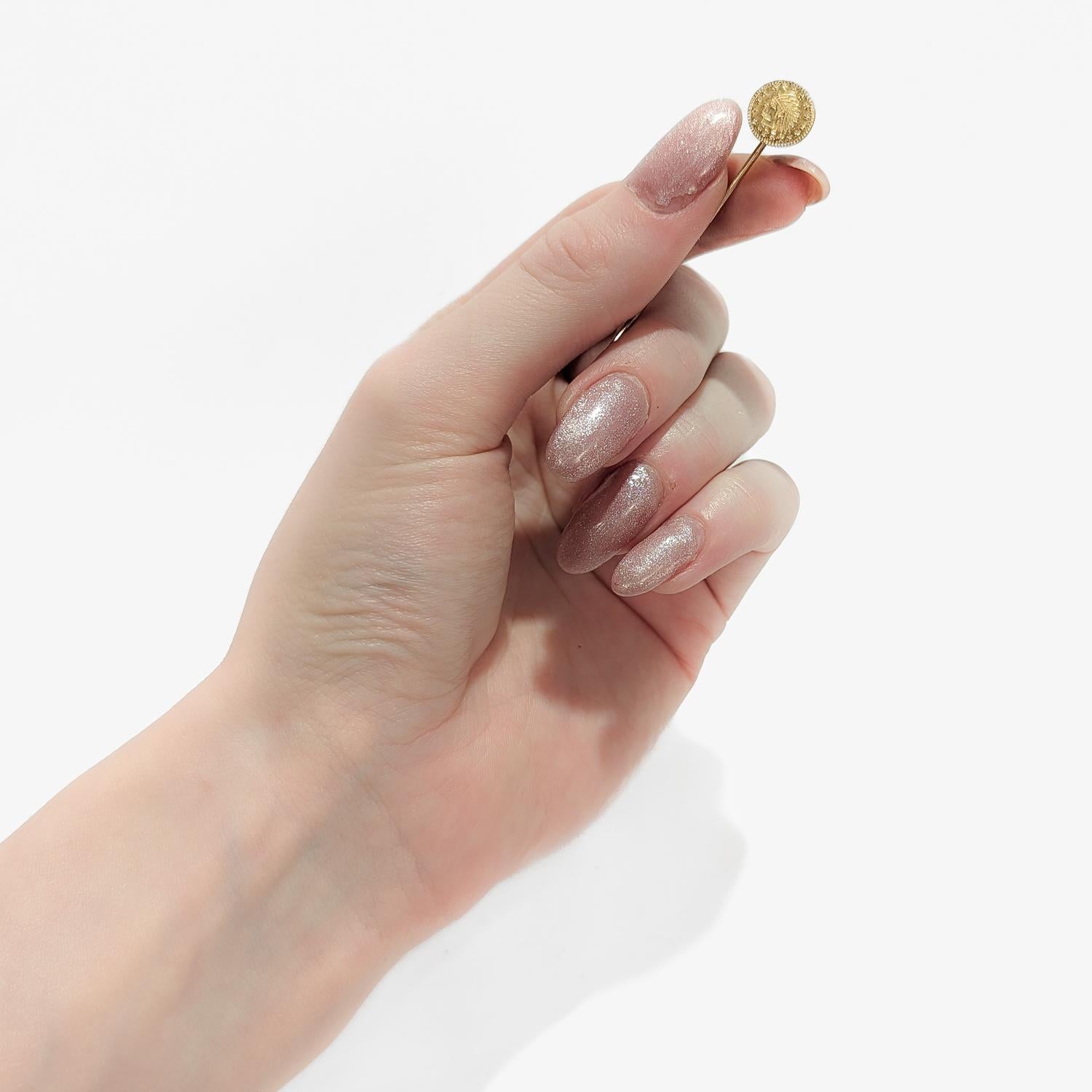 A fine vintage stickpin

In 14 karat yellow gold with a gold-filled post.

The head of the stickpin is a replica of the American 1854 3 dollar gold coin depicting an Indian (Native American) princess.

Simply a wonderful piece of numismatic